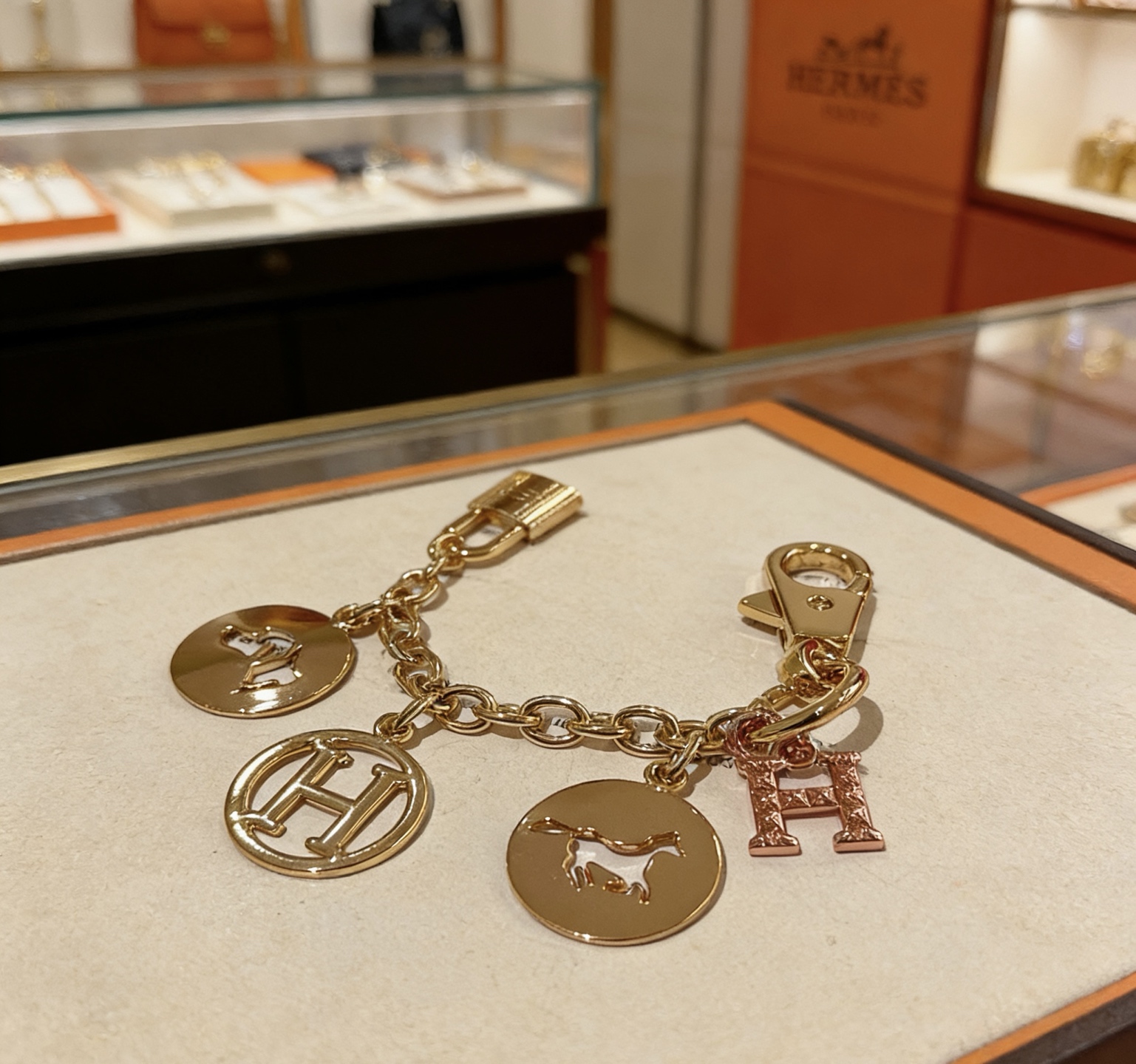 Ciondolo portachiavi con logo Hermes Equestrian H. Metallo color oro con pavé in oro rosa. Ciondolo H in smalto nero con accenti di cavallo e cane, lunghezza della catena di 12 cm.