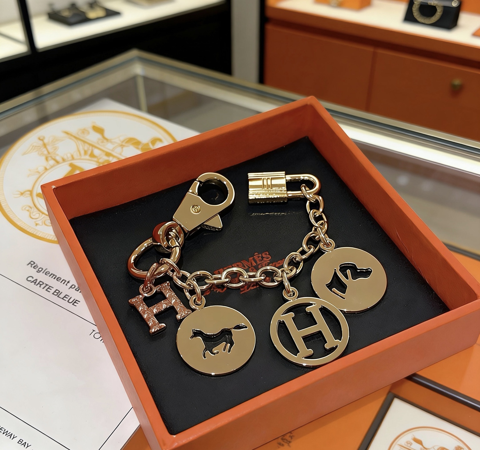 Ciondolo portachiavi con logo Hermes Equestrian H. Metallo color oro con pavé in oro rosa. Ciondolo H in smalto nero con accenti di cavallo e cane, lunghezza della catena di 12 cm.