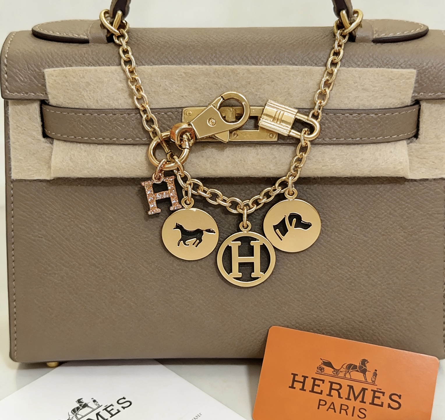 Ciondolo portachiavi con logo Hermes Equestrian H. Metallo color oro con pavé in oro rosa. Ciondolo H in smalto nero con accenti di cavallo e cane, lunghezza della catena di 12 cm.