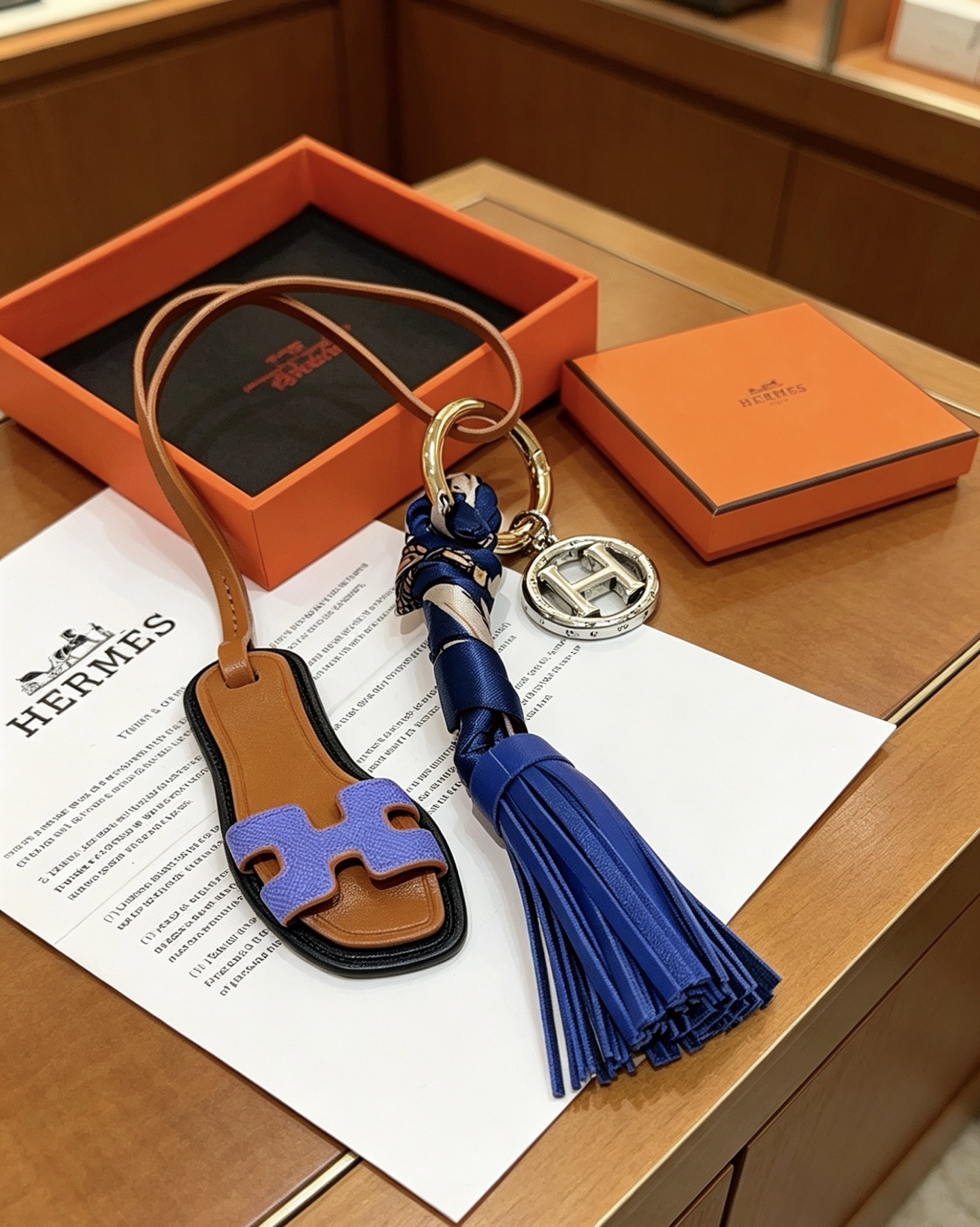 Hermes Oran Sandalo Nappa Chiave Ciondolo con ciondolo Metallo color oro e argento Pelle marrone chiaro Lavanda Pelle viola Pelle blu reale Seta stampata blu scuro Lunghezza totale cinturino 15 cm