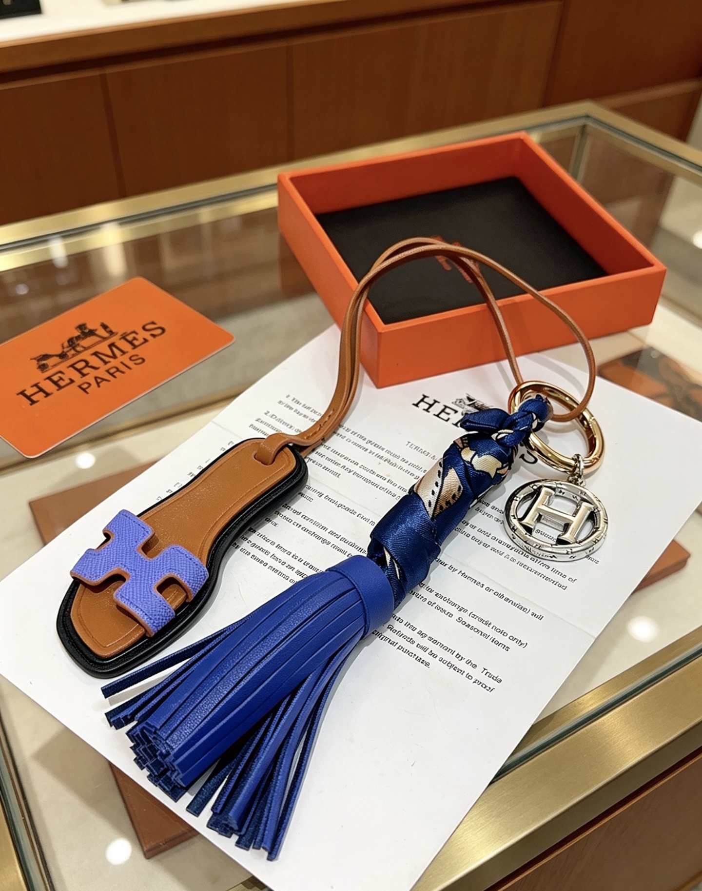 Hermes Oran Sandalo Nappa Chiave Ciondolo con ciondolo Metallo color oro e argento Pelle marrone chiaro Lavanda Pelle viola Pelle blu reale Seta stampata blu scuro Lunghezza totale cinturino 15 cm