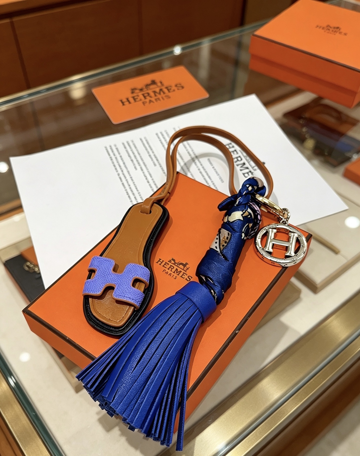 Hermes Oran Sandalo Nappa Chiave Ciondolo con ciondolo Metallo color oro e argento Pelle marrone chiaro Lavanda Pelle viola Pelle blu reale Seta stampata blu scuro Lunghezza totale cinturino 15 cm