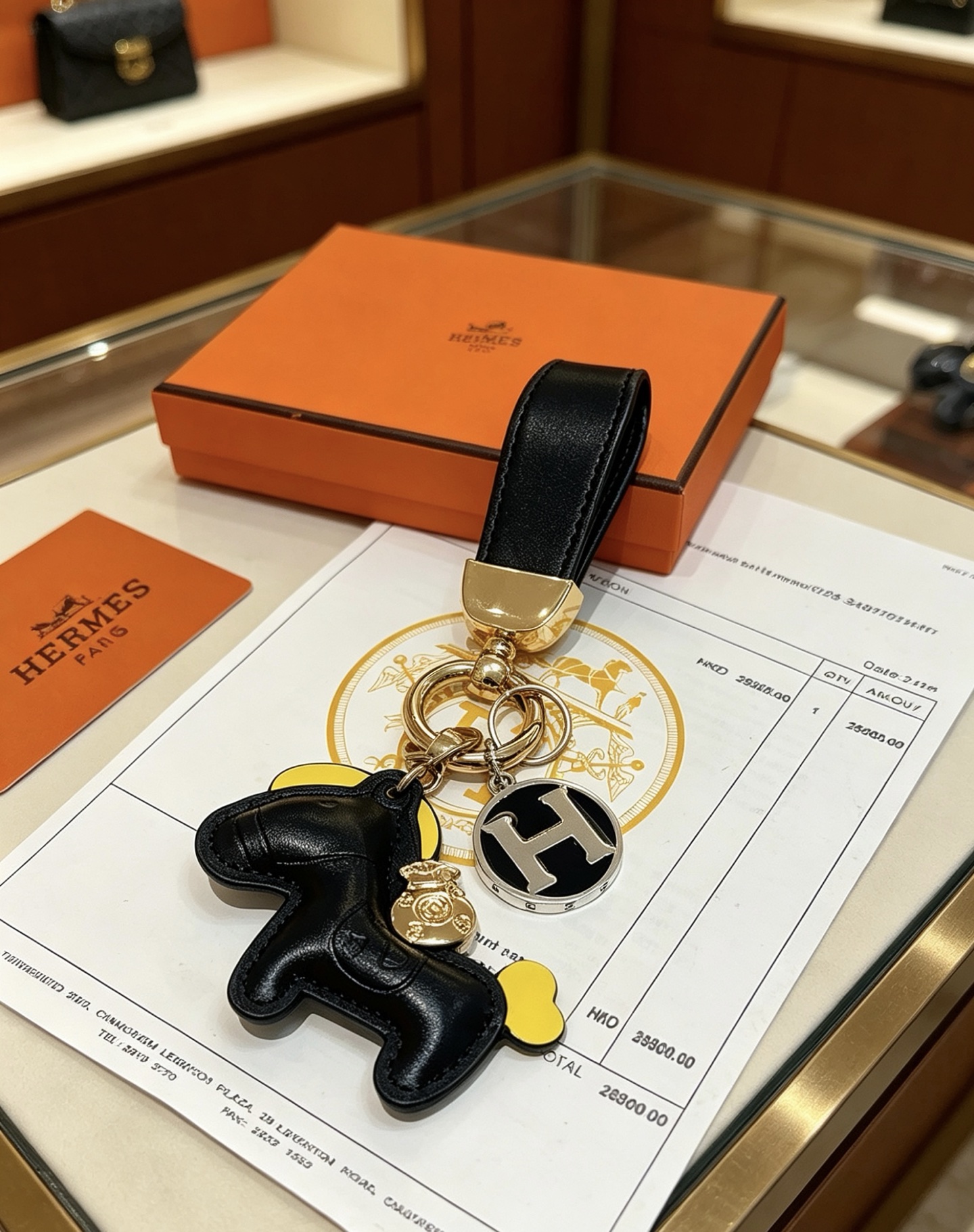 Hermes Rodeo Horse H Logo Key Charm colgante Cuero negro acento amarillo metal dorado logo H plateado con esmalte negro 12 cm de longitud total