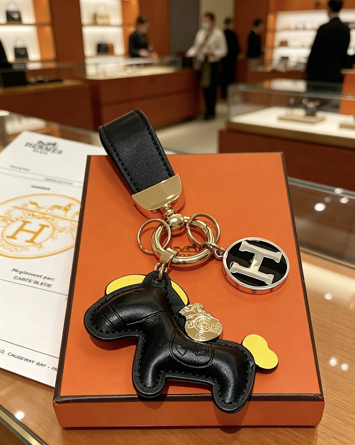 Hermes Rodeo Horse H Logo Key Charm colgante Cuero negro acento amarillo metal dorado logo H plateado con esmalte negro 12 cm de longitud total