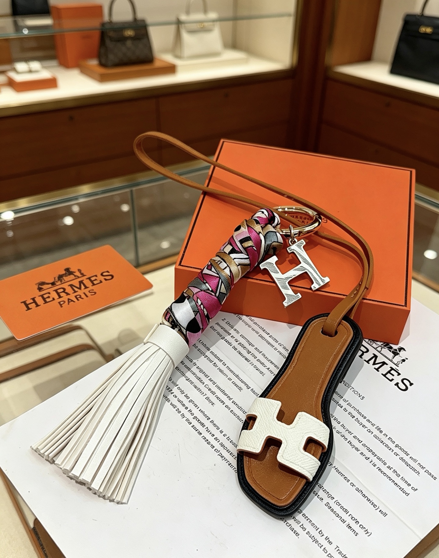 Hermes Oran Sandália Tassel H Charm Chaveiro pingente Metal dourado tom prateado H charme couro marrom couro branco multicolor rosa branco preto ouro seda borla de couro branco acabamento preto 18 cm de comprimento da pulseira