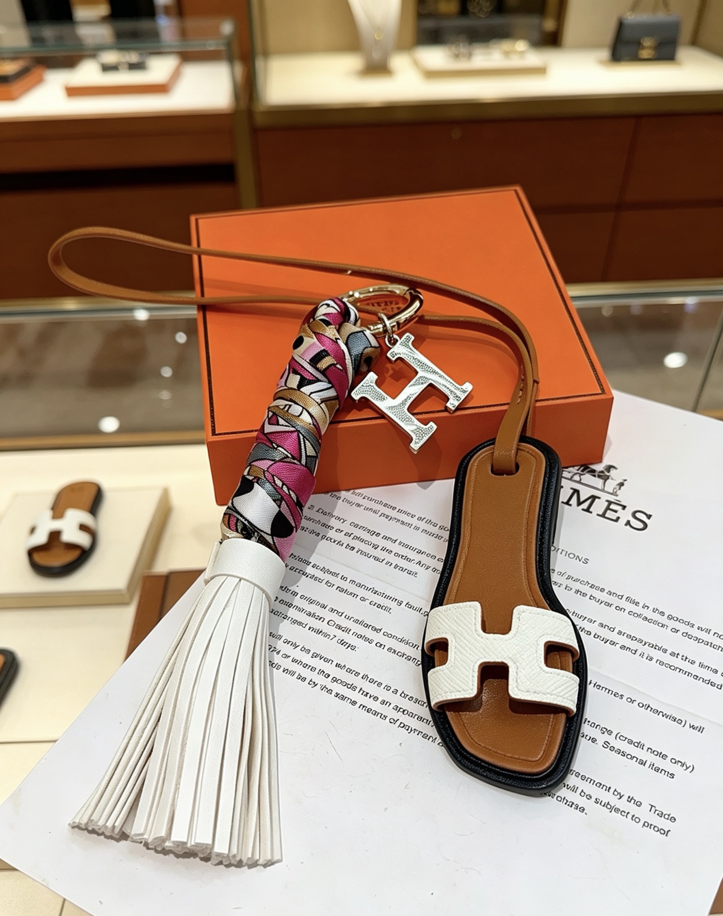 Hermes Oran Sandália Tassel H Charm Chaveiro pingente Metal dourado tom prateado H charme couro marrom couro branco multicolor rosa branco preto ouro seda borla de couro branco acabamento preto 18 cm de comprimento da pulseira