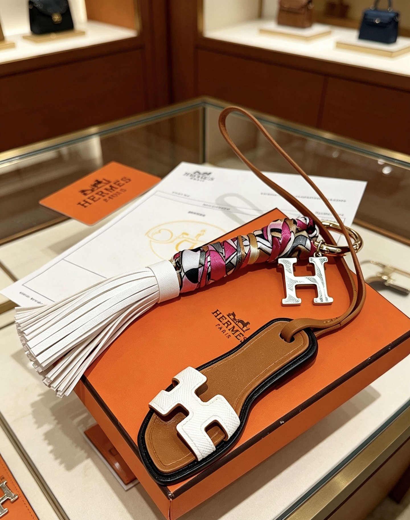 Hermes Oran Sandália Tassel H Charm Chaveiro pingente Metal dourado tom prateado H charme couro marrom couro branco multicolor rosa branco preto ouro seda borla de couro branco acabamento preto 18 cm de comprimento da pulseira