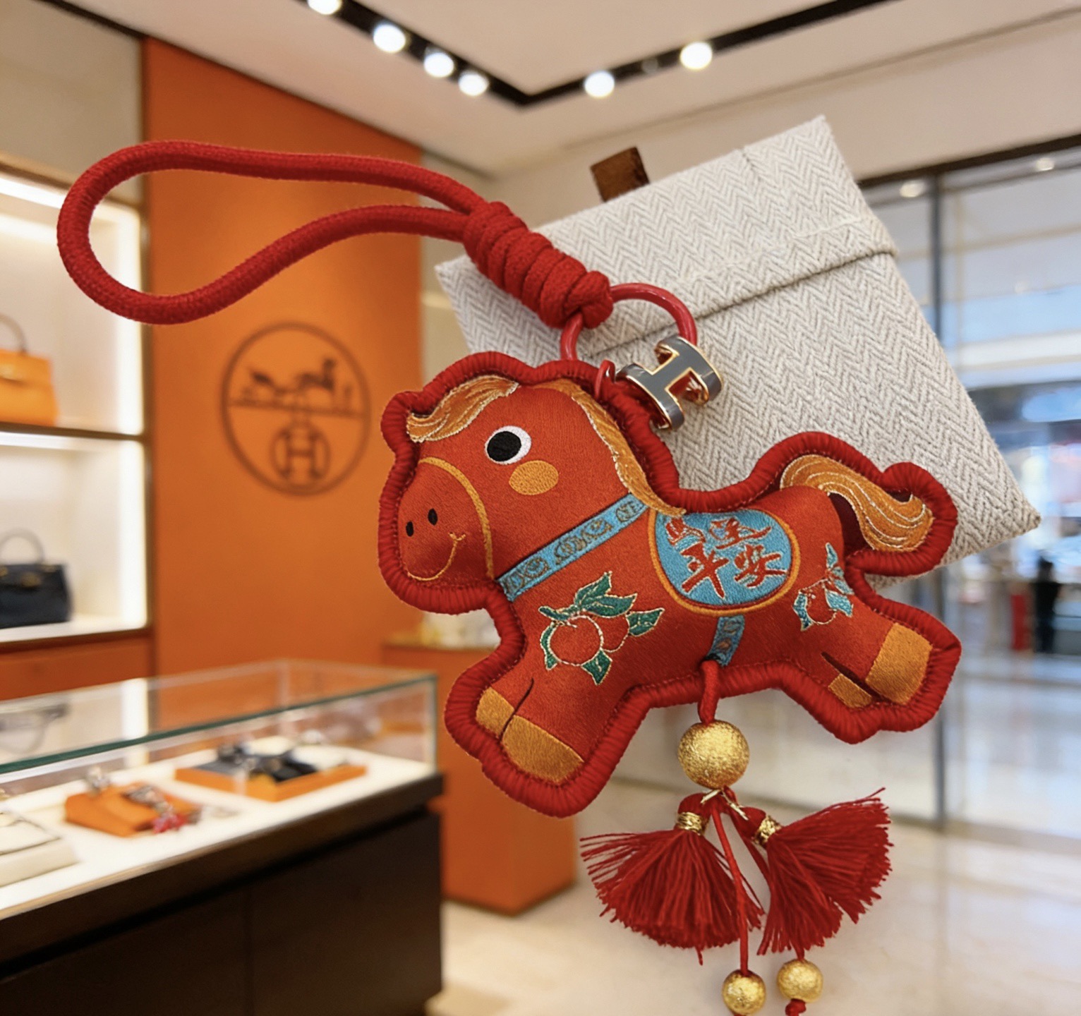 Ciondolo Hermes Rodeo Capodanno cinese a forma di cavallo Tessuto rosso con ricami dorati Dettagli accenti blu Hardware in metallo dorato Nappe rosse Ciondolo da 10 cm con cordino da 8 cm