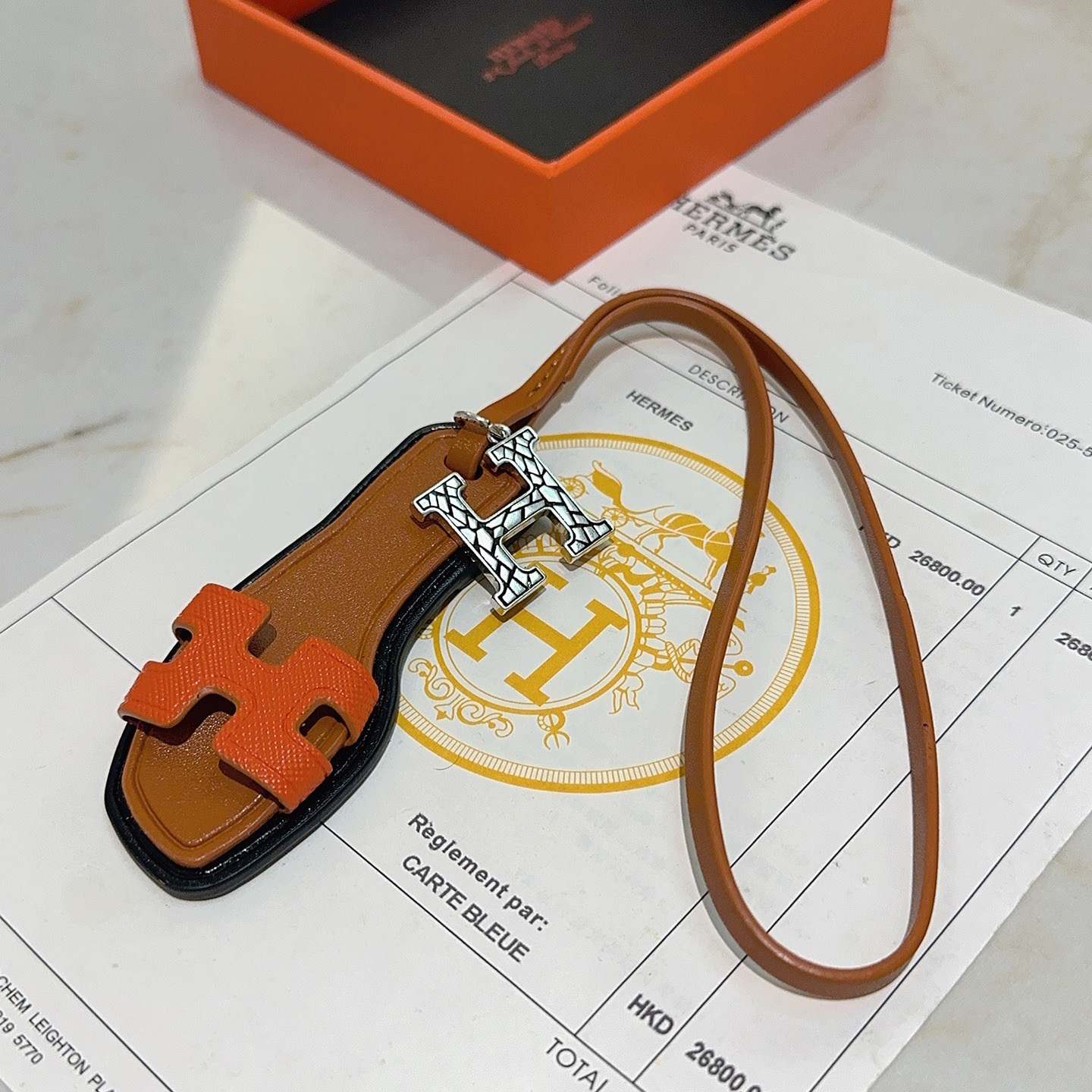 Hermes Oran Sandal Bag Charm colgante Metal plateado naranja Cuero Epsom dorado Cuero Swift ribete de borde negro Longitud de la correa de 17 cm