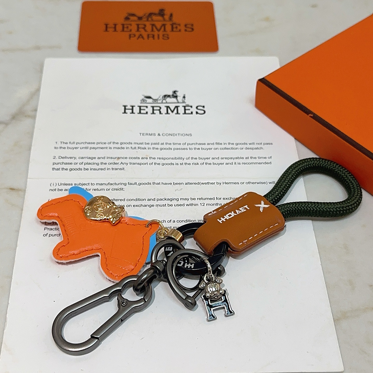 Hermes Rodeo Horse Charm Porte-clés pendentif Breloque cheval en cuir orange avec accents bleus bracelet en cuir marron cordon tressé vert foncé matériel en bronze à canon breloque de sac d'argent doré breloque logo H argenté 10 cm de longueur totale