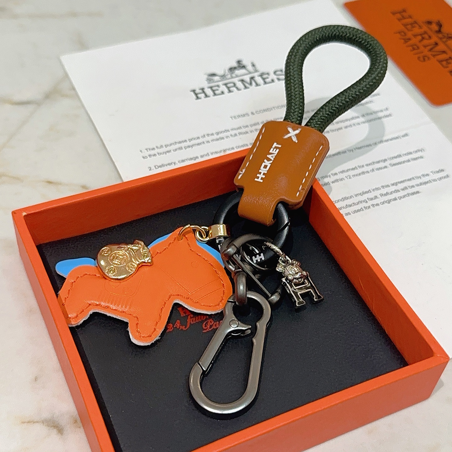 Hermes Rodeo Horse Charm Porte-clés pendentif Breloque cheval en cuir orange avec accents bleus bracelet en cuir marron cordon tressé vert foncé matériel en bronze à canon breloque de sac d'argent doré breloque logo H argenté 10 cm de longueur totale