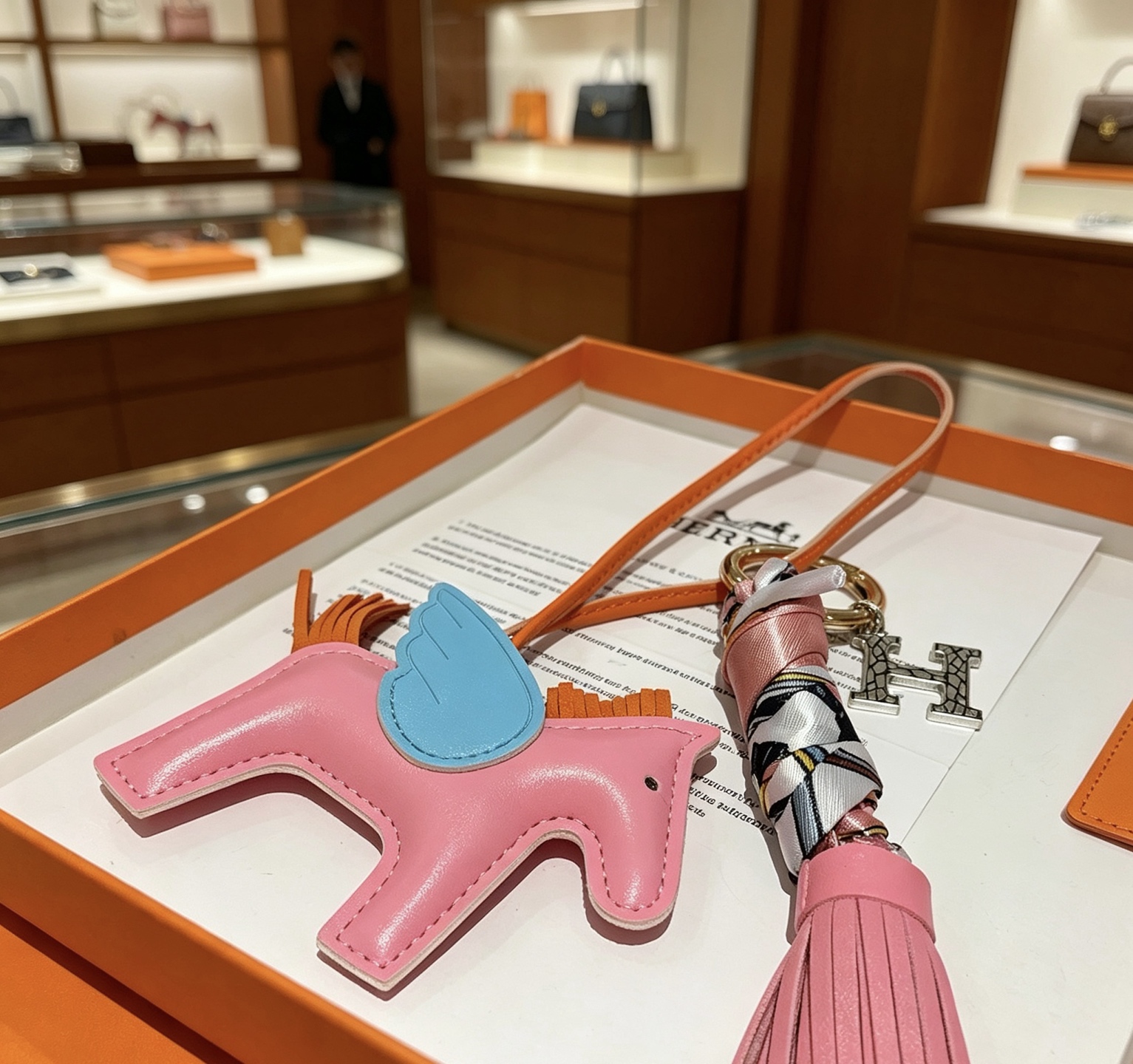 Hermes Rodeo Pegase Tassel H Charm Porte-clés pendentif Cuir rose avec ailes bleu clair crinière orange queue pompon rose matériel en métal doré enveloppe de soie multicolore breloque H argentée 12 cm de longueur totale