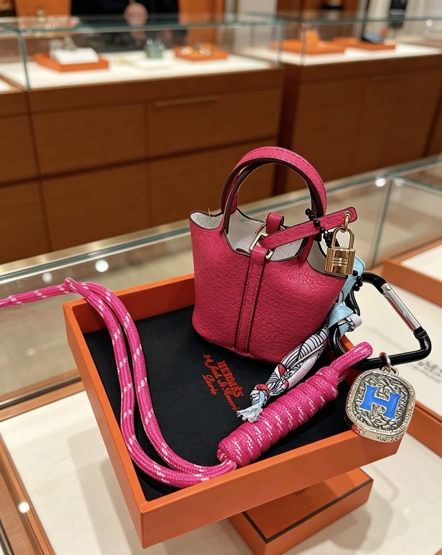 Pendentif Hermes Mini Picotin Lock Bag Charm Cuir grainé rose rose Quincaillerie en métal doré rose Métal argenté avec émail bleu Logo H Accent en twilly de soie imprimé multicolore Longueur totale 20 cm