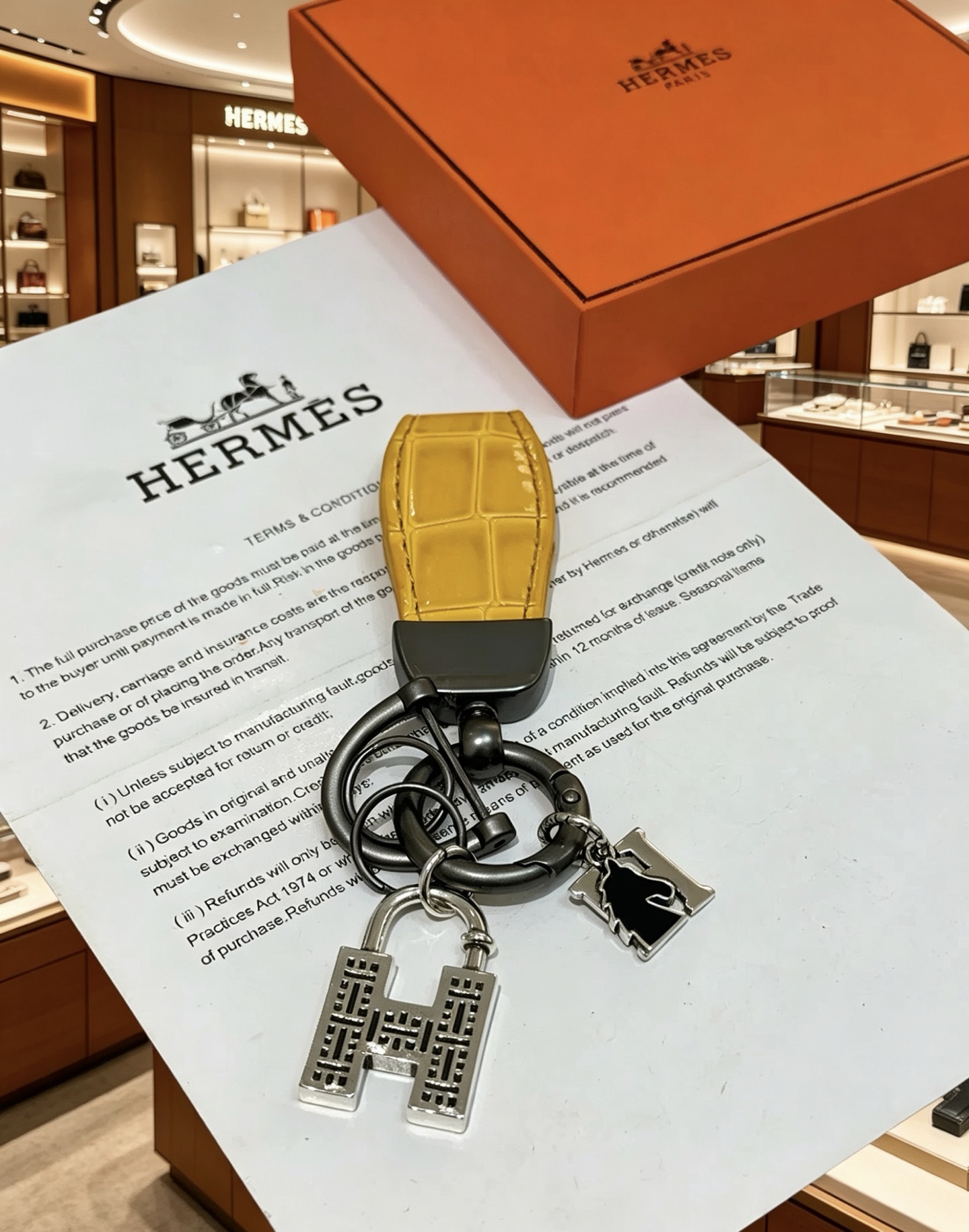 Ciondolo Hermes H lucchetto coccodrillo chiave canna di fucile metallo argentato pelle di alligatore giallo smalto nero lunghezza totale 10 cm