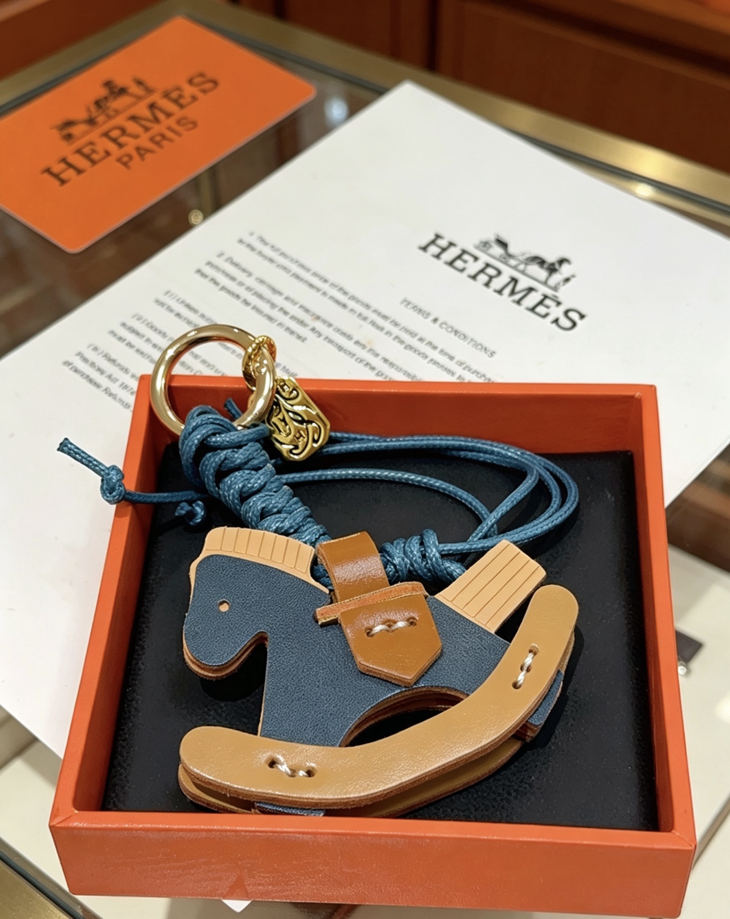 Ciondolo con ciondolo per borsa Hermes con cavallo a dondolo Cavo intrecciato in metallo color oro blu intenso marrone chiaro blu scuro e pelle beige chiaro lunghezza totale 12 cm