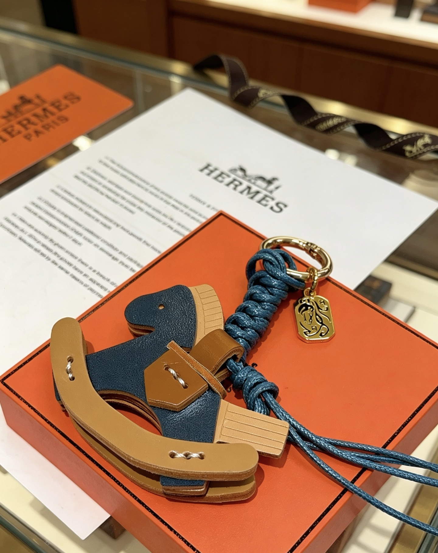 Ciondolo con ciondolo per borsa Hermes con cavallo a dondolo Cavo intrecciato in metallo color oro blu intenso marrone chiaro blu scuro e pelle beige chiaro lunghezza totale 12 cm