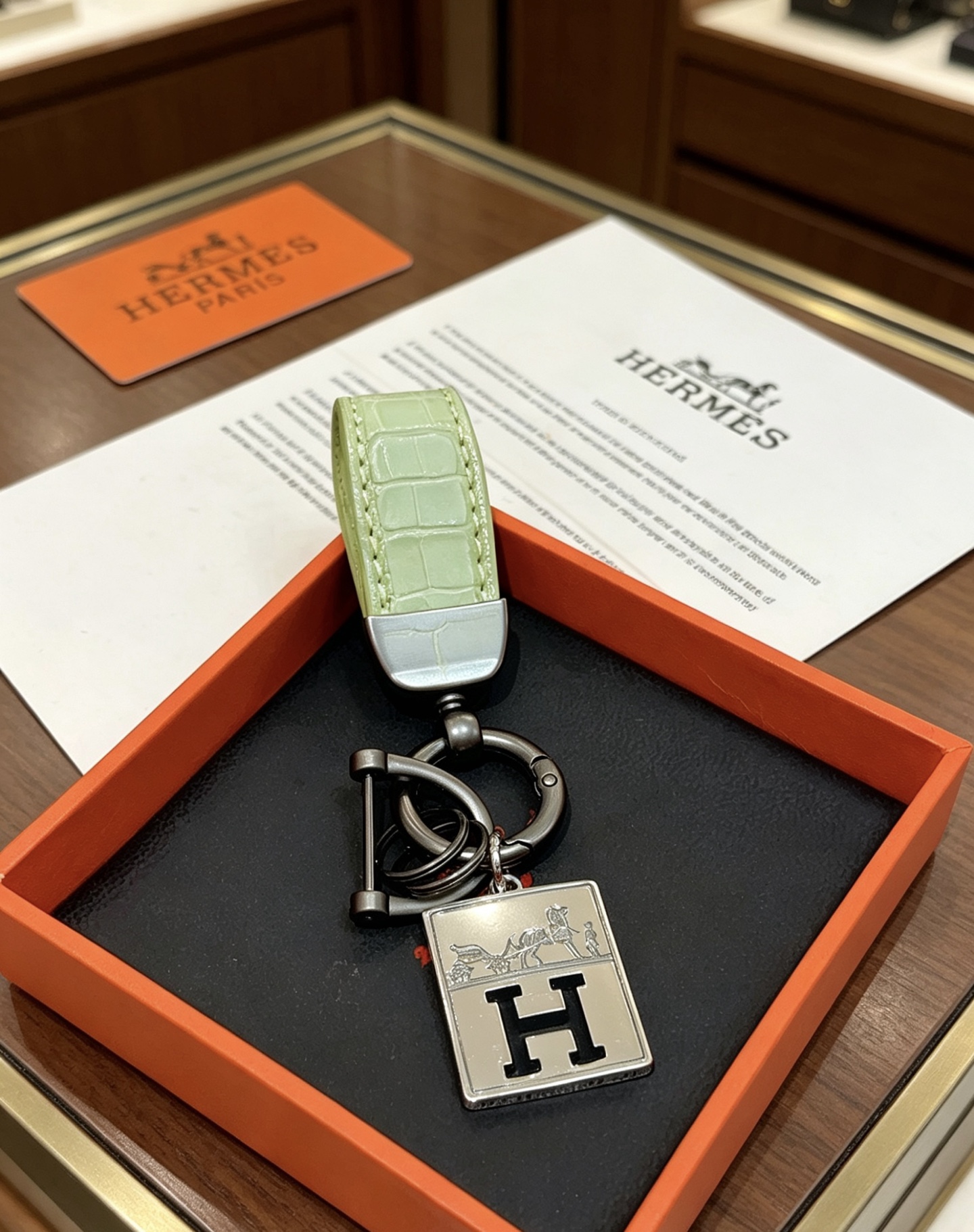 Ciondolo Hermes H Logo Caleche Key Metallo color argento canna di fucile con pelle di coccodrillo verde chartreuse goffrata, lunghezza totale 10 cm