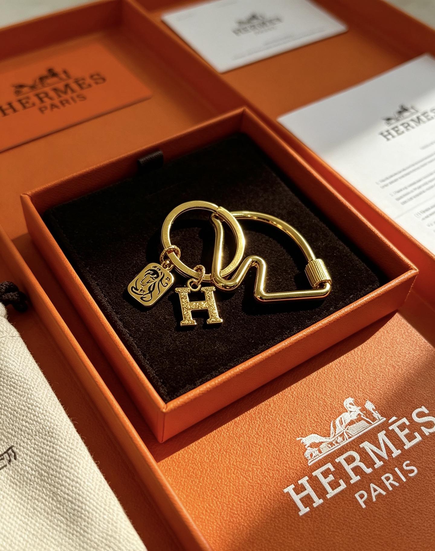Hermes Olympia H Charm Key Ring pendant gold-tone metal with clear crystal pave H charm and black enamel horse motif charm 3 5cm ring diameter