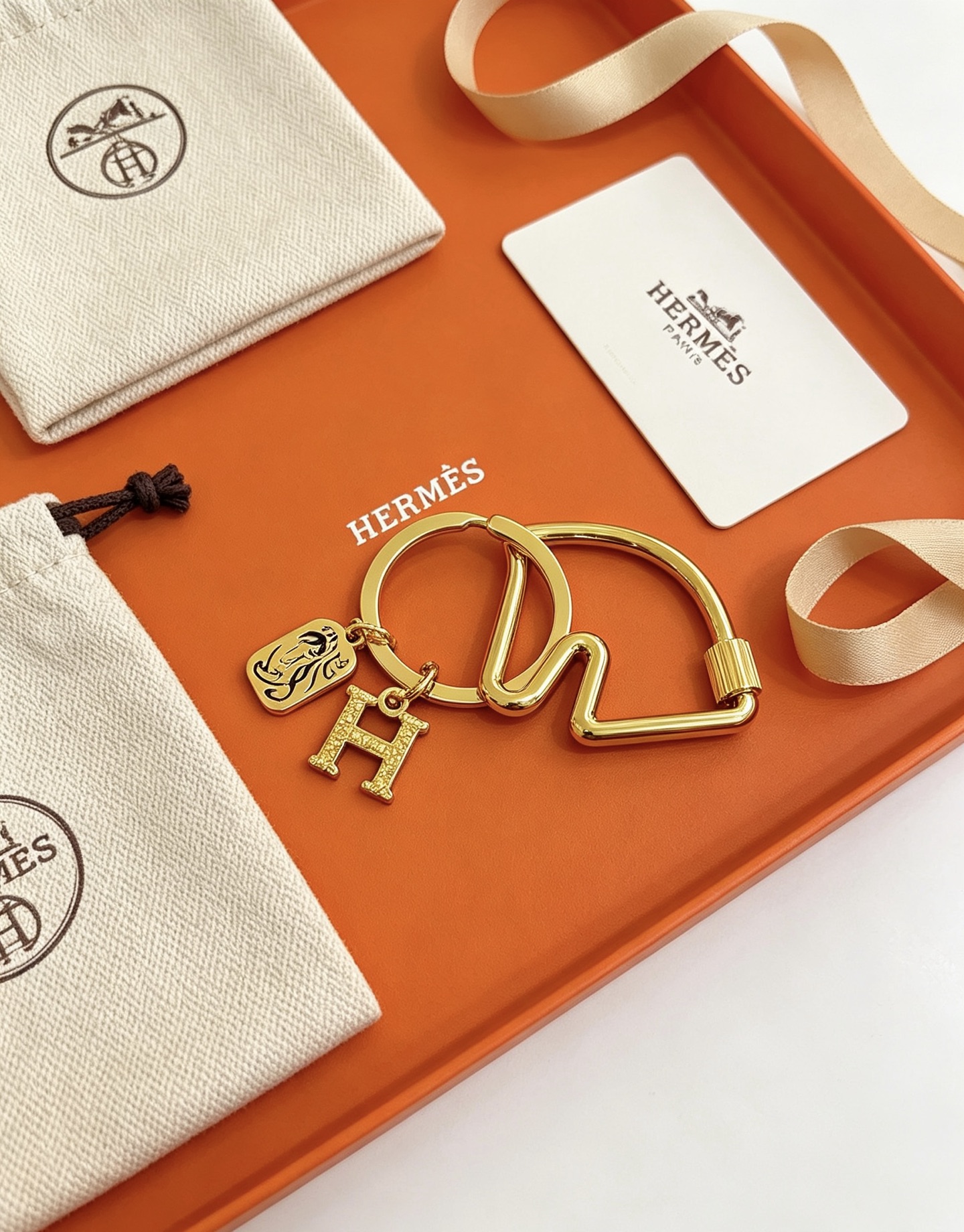Hermes Olympia H Charm Key Ring pendant gold-tone metal with clear crystal pave H charm and black enamel horse motif charm 3 5cm ring diameter