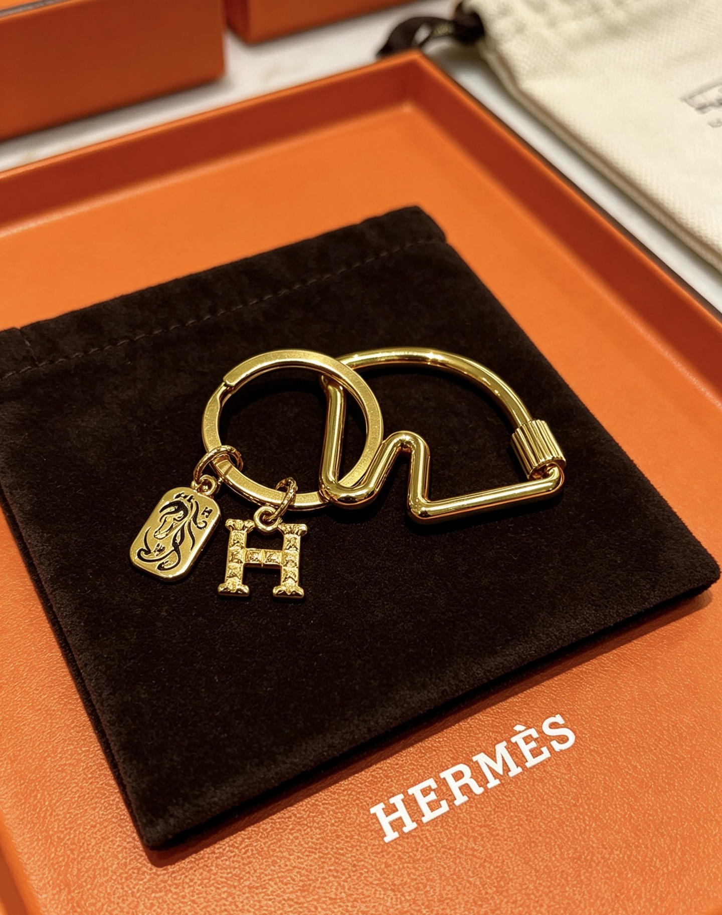 Hermes Olympia H Charm Key Ring pendant gold-tone metal with clear crystal pave H charm and black enamel horse motif charm 3 5cm ring diameter