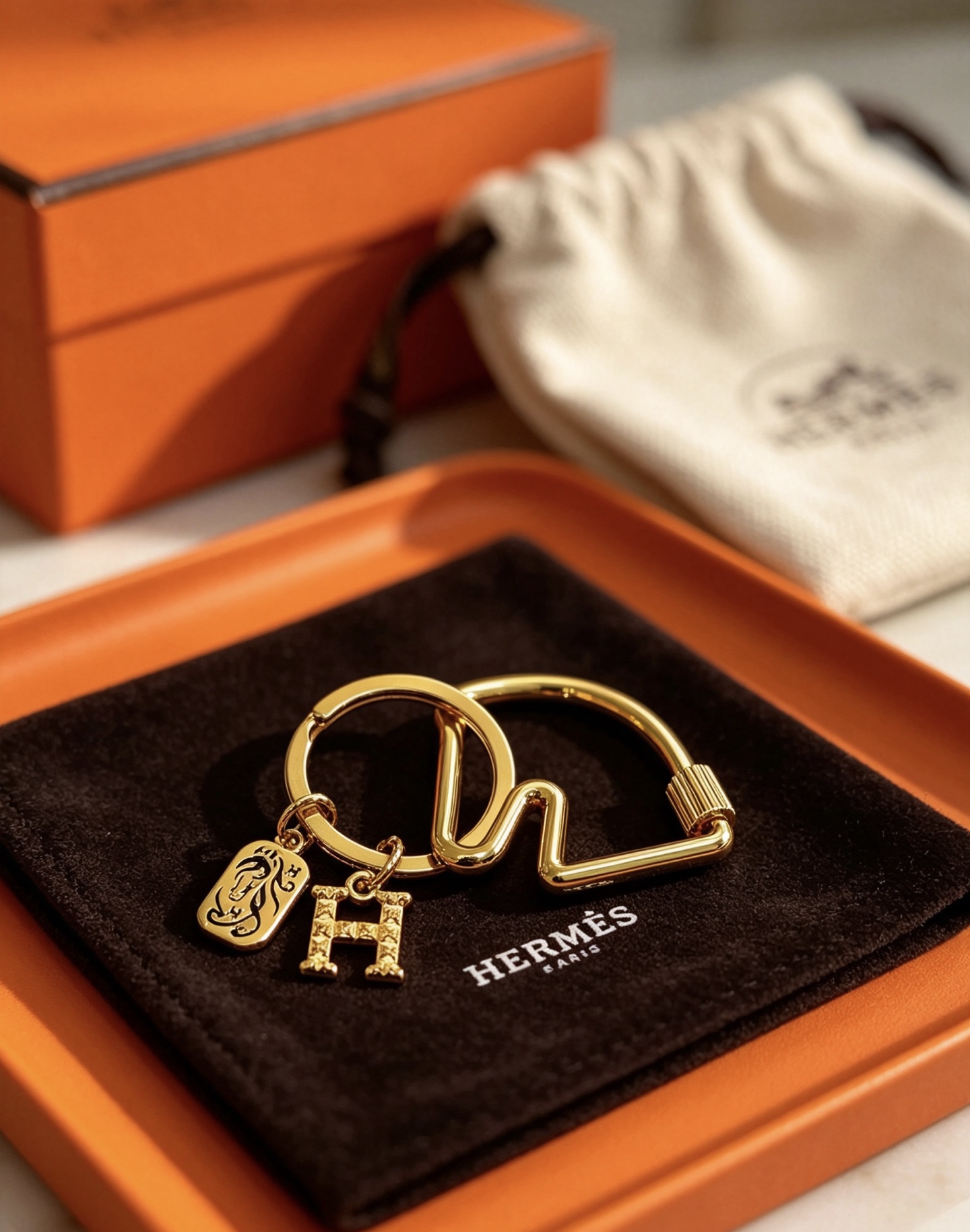 Hermes Olympia H Charm Key Ring pendant gold-tone metal with clear crystal pave H charm and black enamel horse motif charm 3 5cm ring diameter