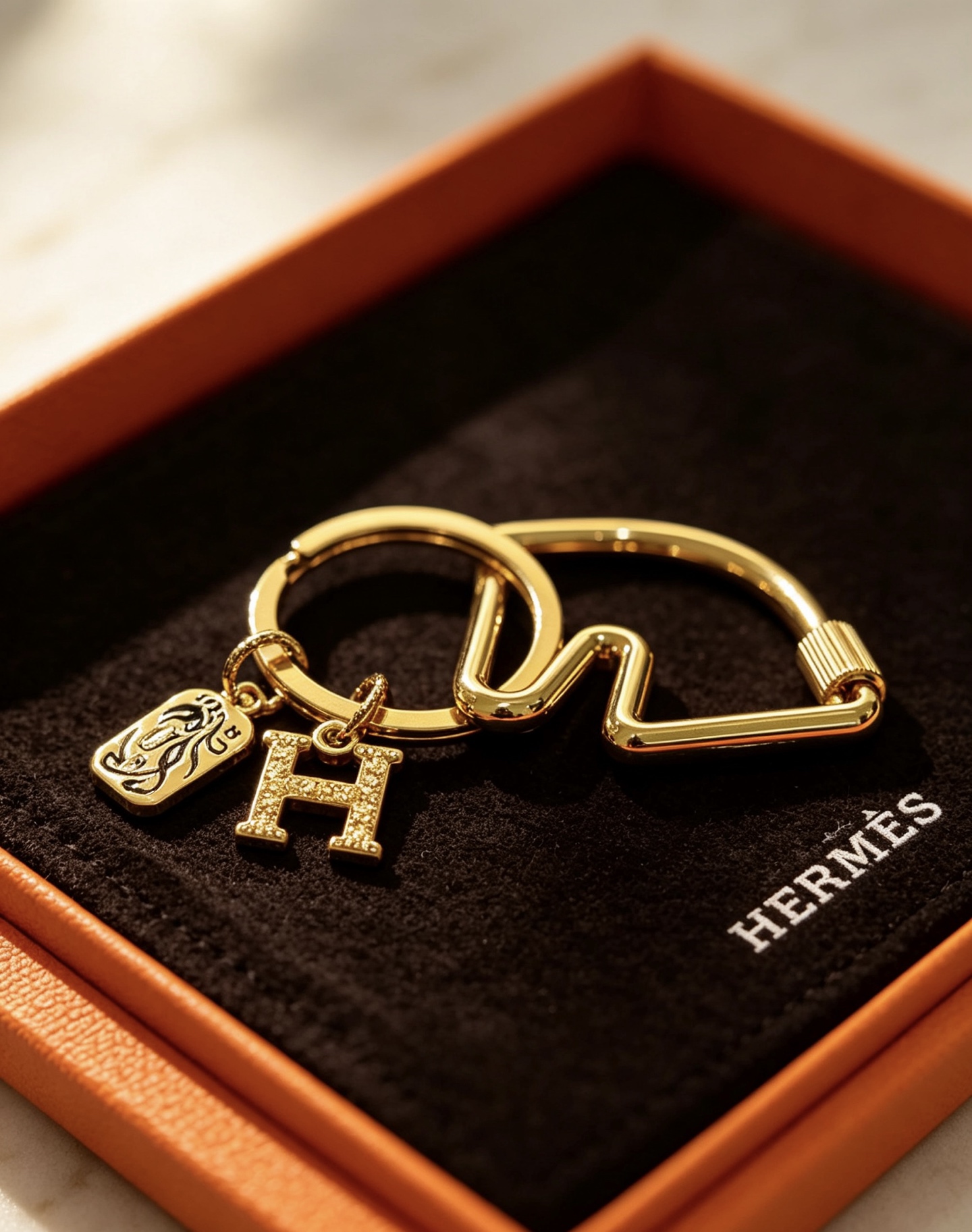 Hermes Olympia H Charm Key Ring pendant gold-tone metal with clear crystal pave H charm and black enamel horse motif charm 3 5cm ring diameter