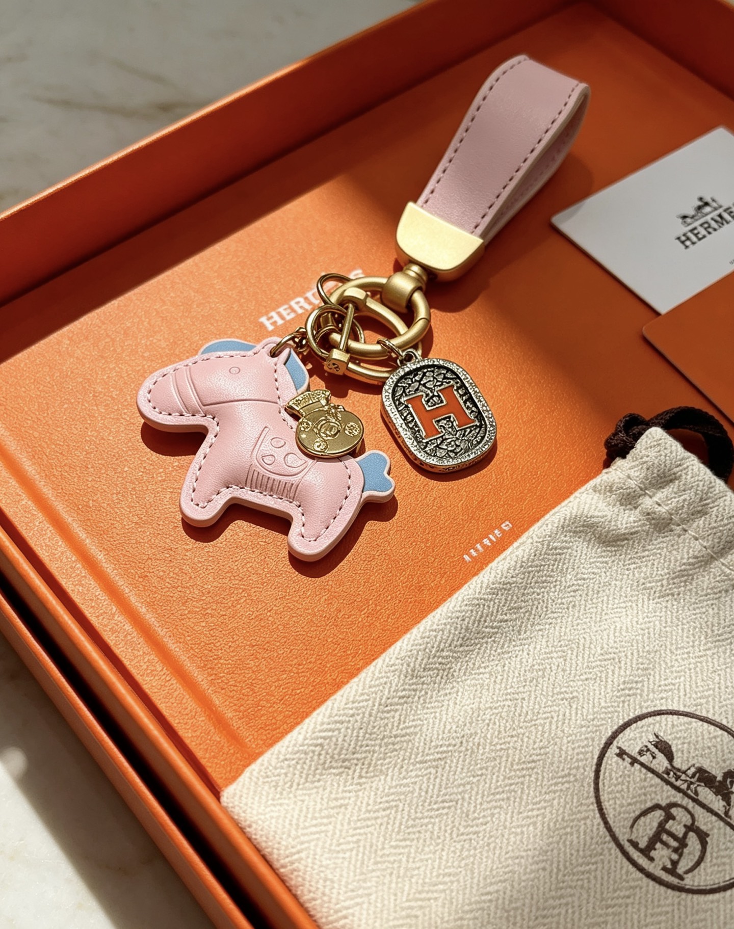 Ciondolo Hermes Rodeo Horse H Logo Key Charm Pelle rosa con accenti azzurri color oro e metallo argentato antico dettaglio H smaltato arancione 10 cm di lunghezza totale