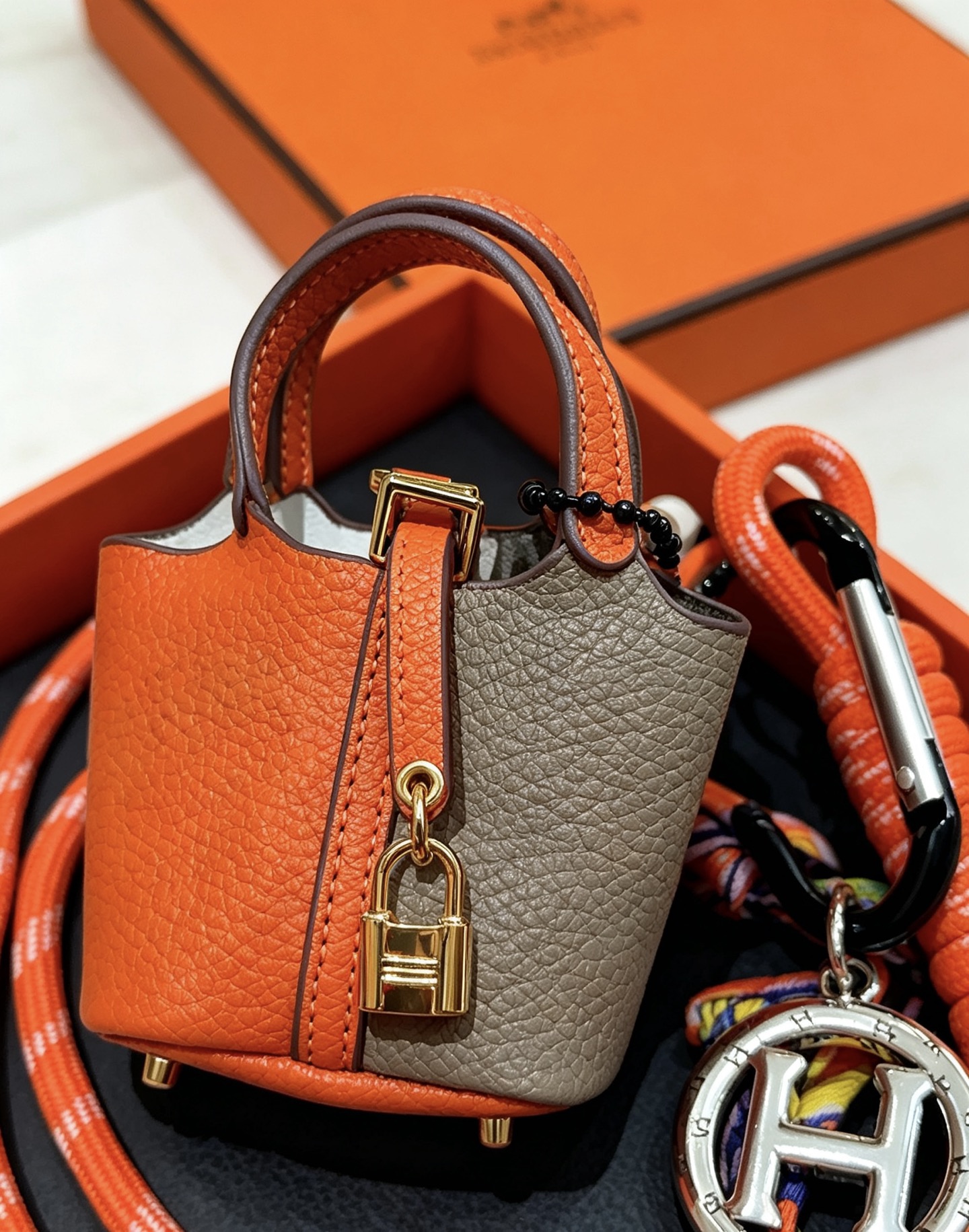 Hermes Mini Picotin Lock Bag Ciondolo con ciondolo Pelle arancione e grigia Hardware in metallo color oro Ciondolo con logo H color argento Accenti di cavo di seta multicolore 80 cm