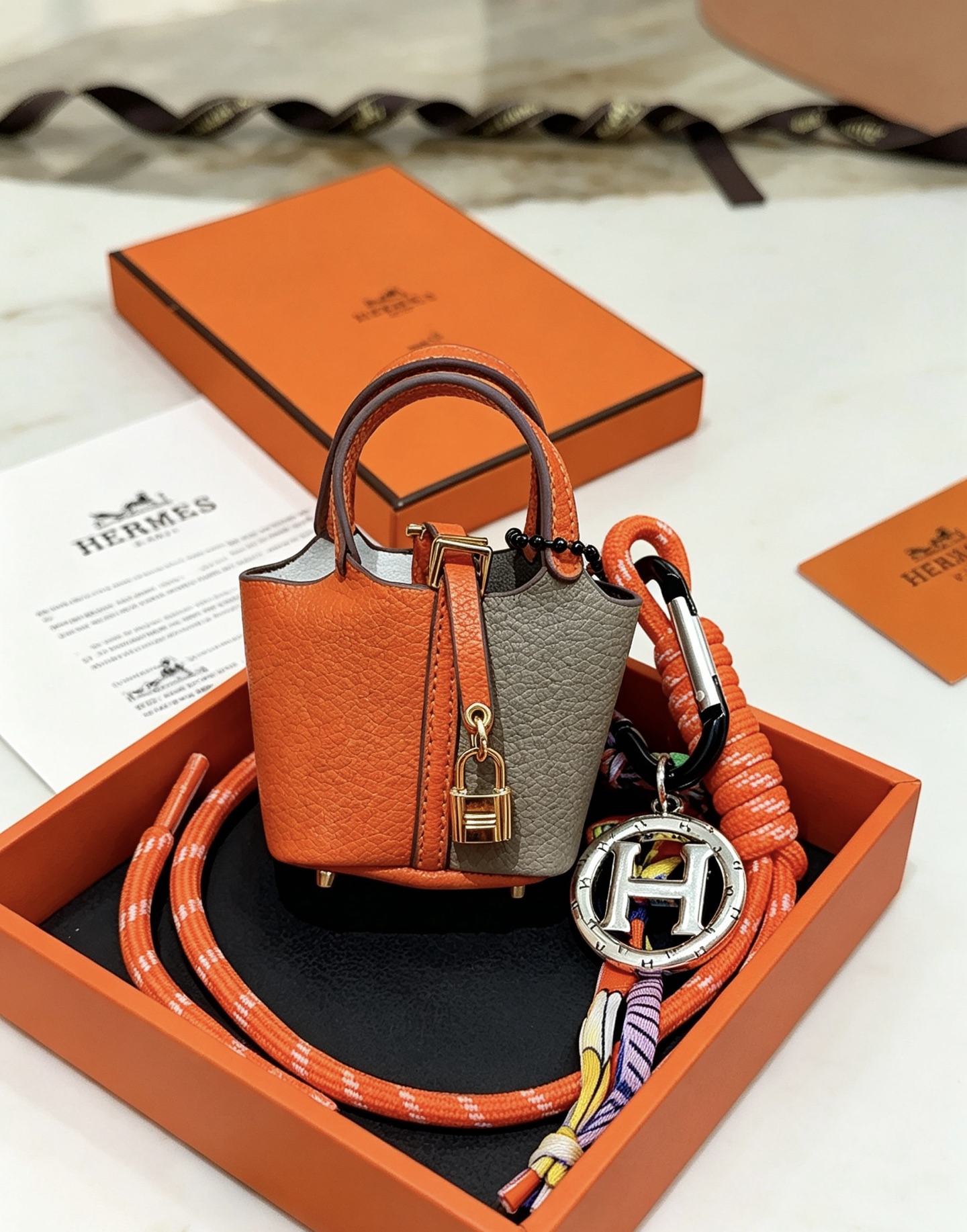 Hermes Mini Picotin Lock Bag Ciondolo con ciondolo Pelle arancione e grigia Hardware in metallo color oro Ciondolo con logo H color argento Accenti di cavo di seta multicolore 80 cm
