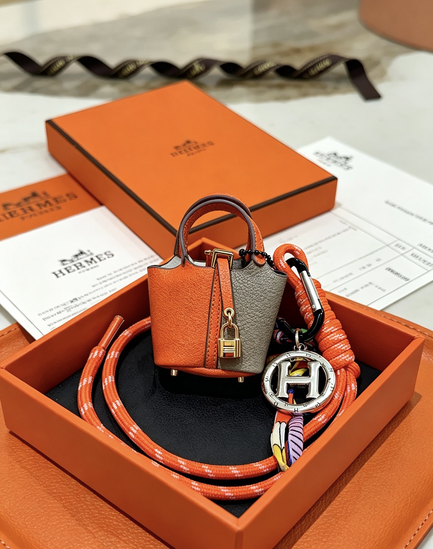 Hermes Mini Picotin Lock Bag Ciondolo con ciondolo Pelle arancione e grigia Hardware in metallo color oro Ciondolo con logo H color argento Accenti di cavo di seta multicolore 80 cm