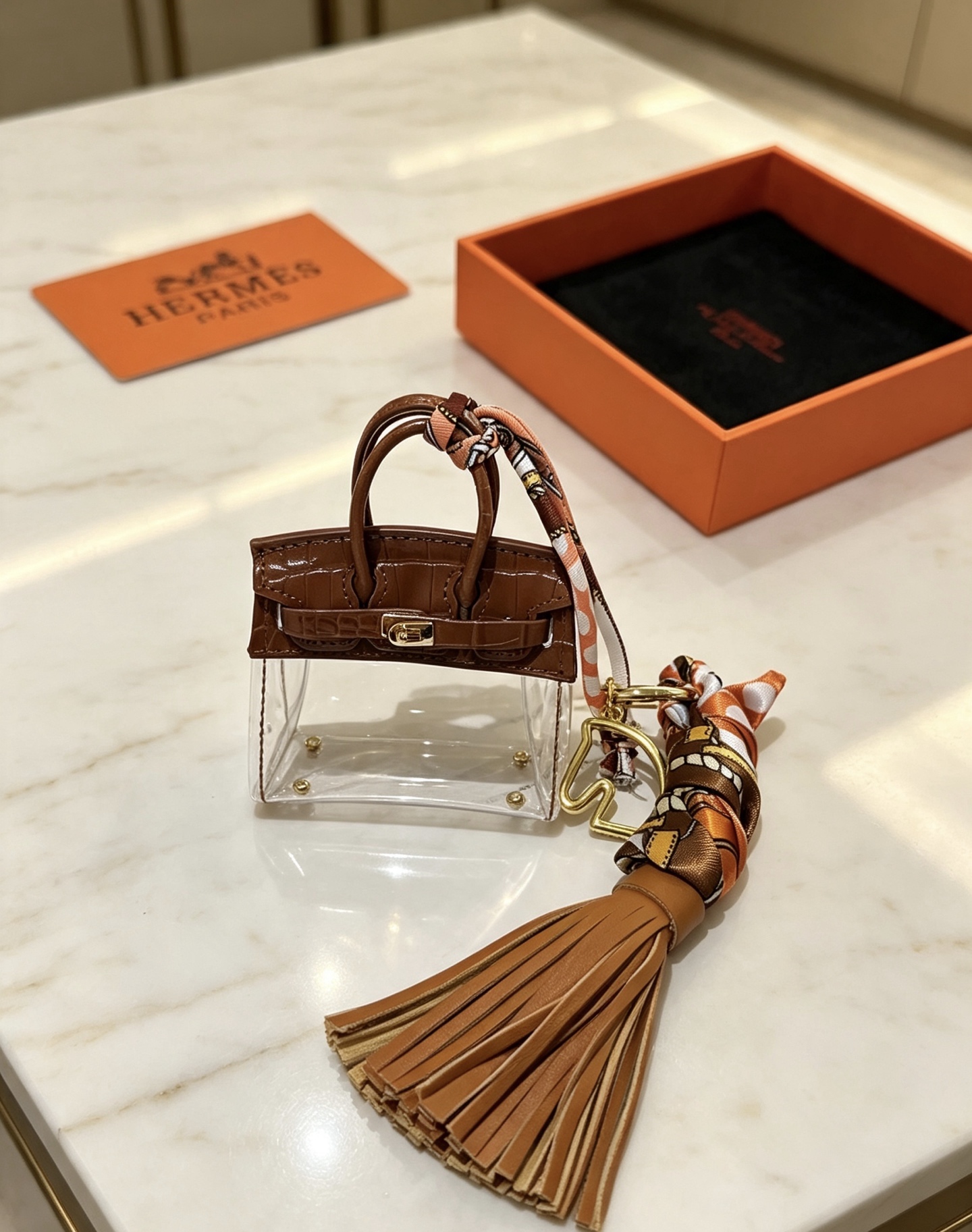 Ciondolo Hermes Birkin Micro Bag Metallo color oro pelle goffrata coccodrillo marrone PVC trasparente nappa in pelle marrone chiaro twilly di seta stampata multicolore lunghezza totale 12 cm