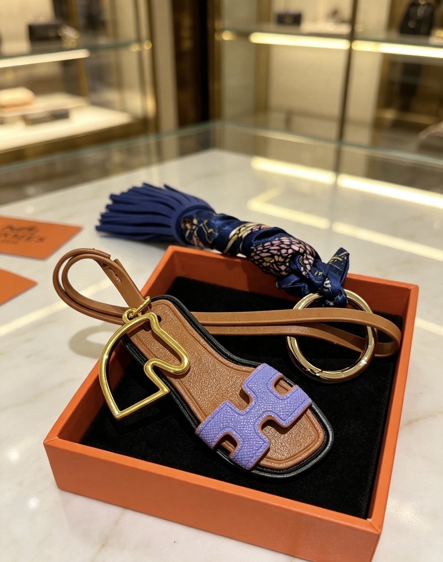 Hermes Oran Sandalia Borla Llavero Colgante Metal dorado Cuero marrón Cuero morado lavanda Cuero azul marino Azul marino Seda estampada Adorno negro Longitud total de 12 cm