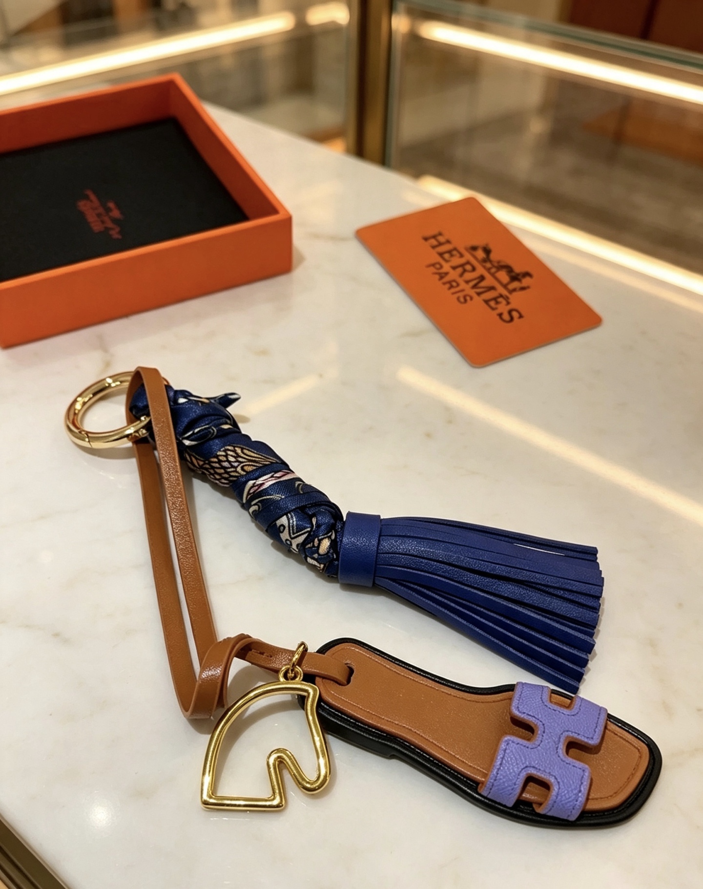 Hermes Oran Sandalia Borla Llavero Colgante Metal dorado Cuero marrón Cuero morado lavanda Cuero azul marino Azul marino Seda estampada Adorno negro Longitud total de 12 cm