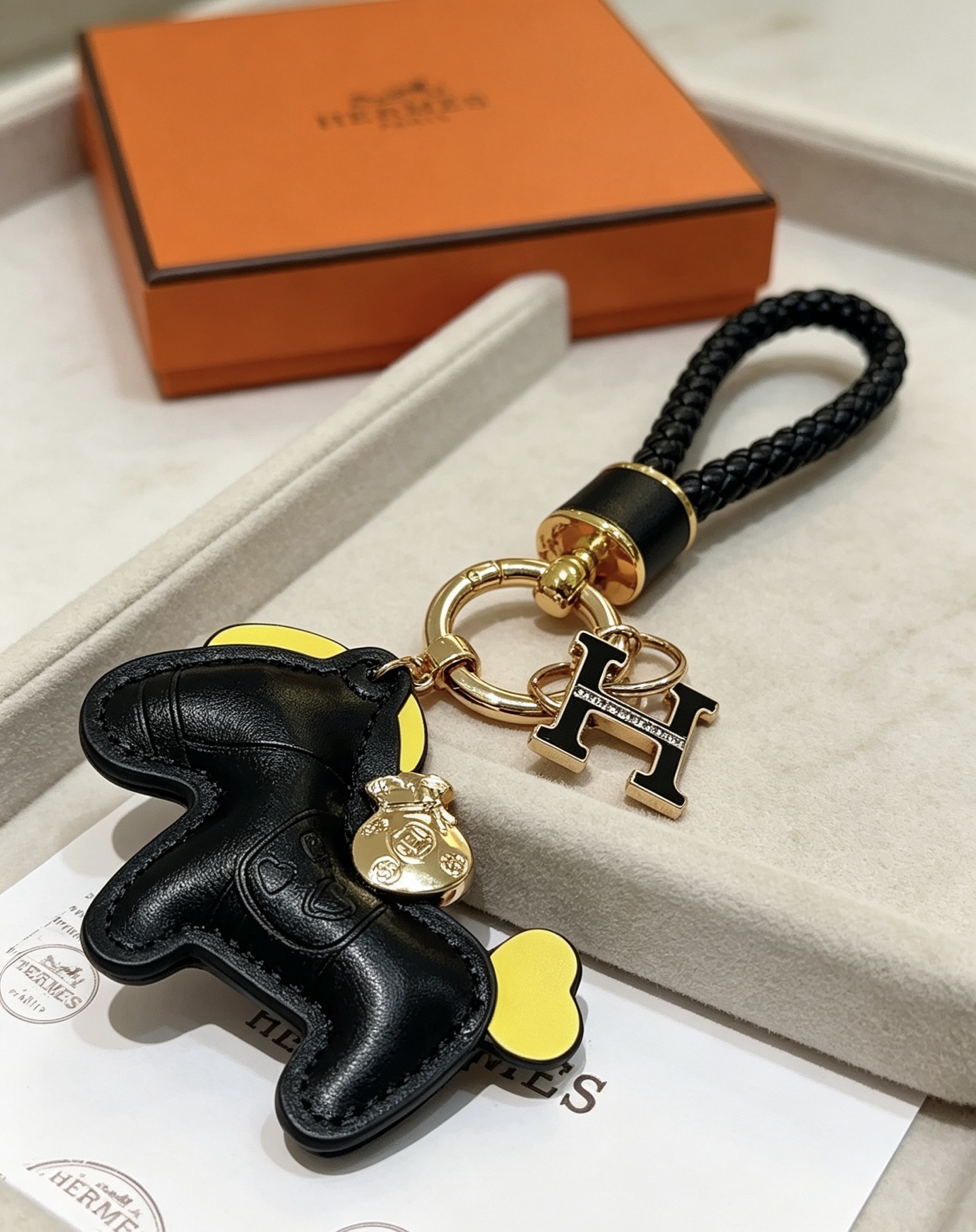 Hermes Rodeo Pony H Logo portachiavi intrecciato ciondolo in pelle nera accento giallo metallo color oro smalto nero ciondolo H 12 cm lunghezza totale