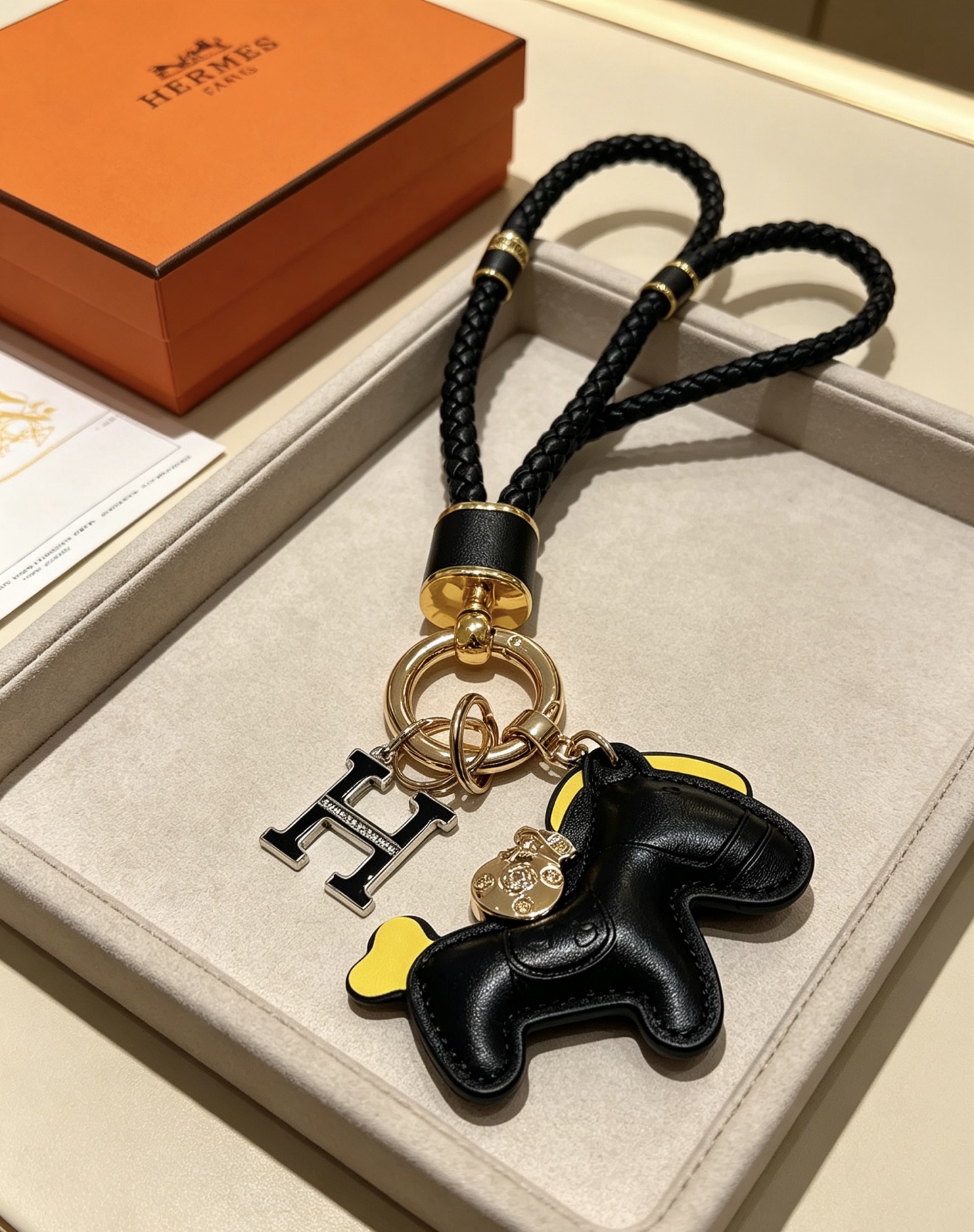 Hermes Rodeo Pony H Logo portachiavi intrecciato ciondolo in pelle nera accento giallo metallo color oro smalto nero ciondolo H 12 cm lunghezza totale