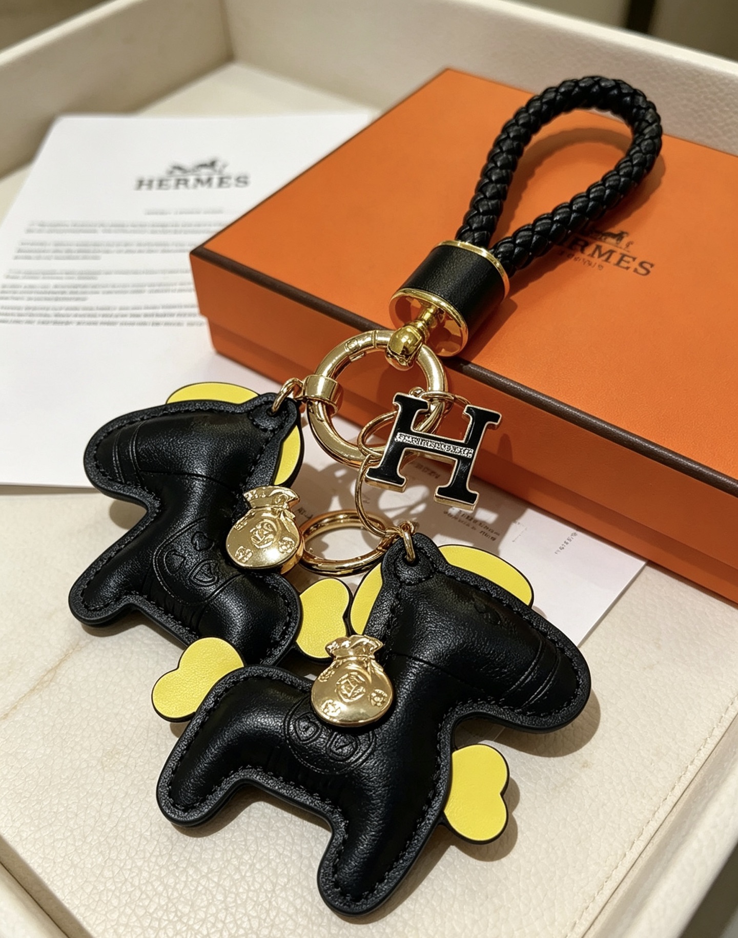 Hermes Rodeo Pony H Logo portachiavi intrecciato ciondolo in pelle nera accento giallo metallo color oro smalto nero ciondolo H 12 cm lunghezza totale