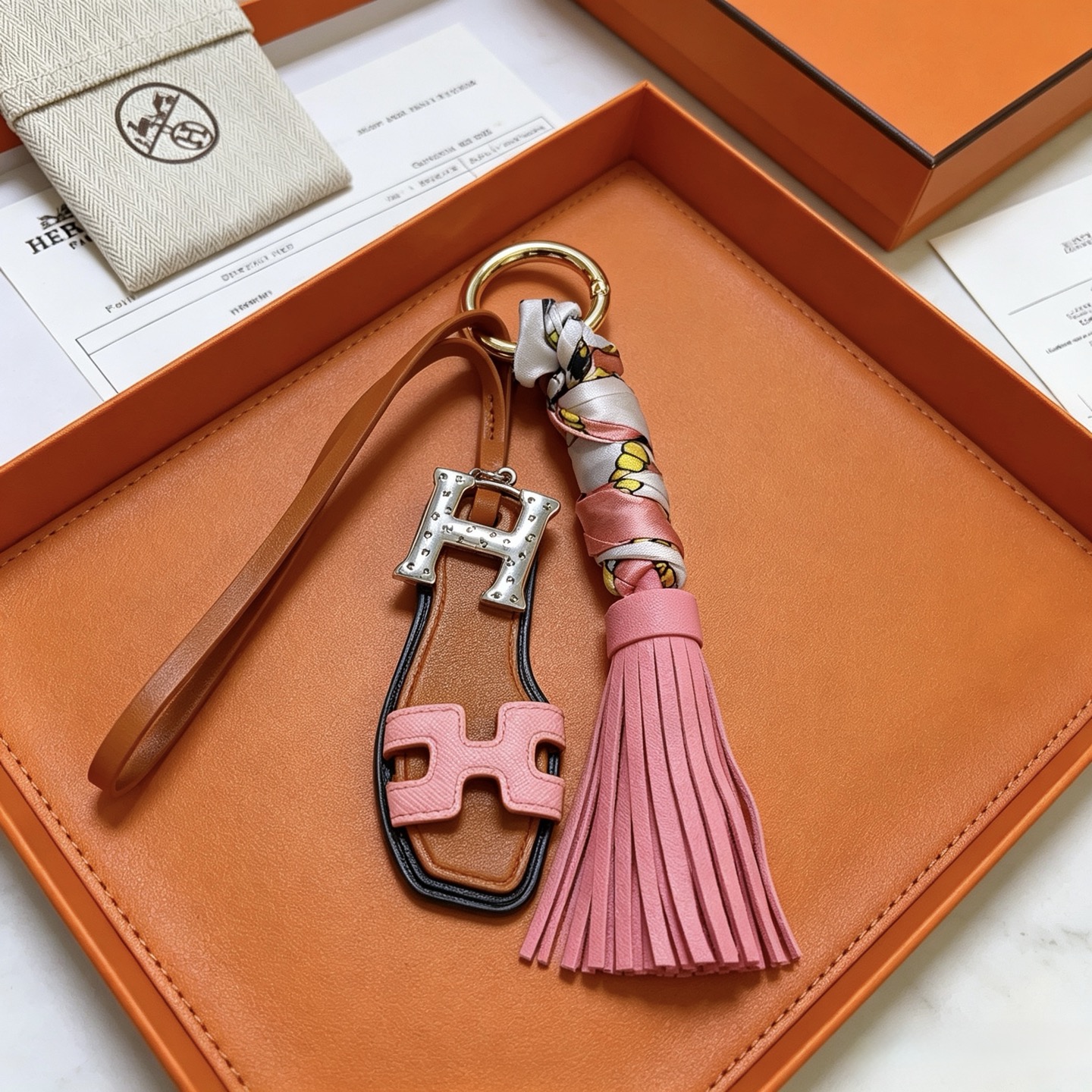 Hermes Oran Sandalo Nappa Chiave Ciondolo ciondolo Metallo tonalità oro Hardware H tonalità argento pelle marrone chiaro pelle rosa seta stampata multicolore bordo nero finiture 12 cm lunghezza totale