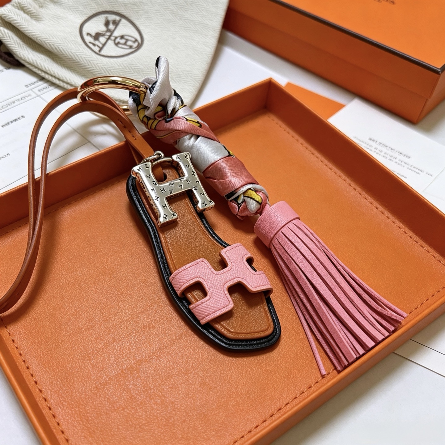 Hermes Oran Sandalo Nappa Chiave Ciondolo ciondolo Metallo tonalità oro Hardware H tonalità argento pelle marrone chiaro pelle rosa seta stampata multicolore bordo nero finiture 12 cm lunghezza totale