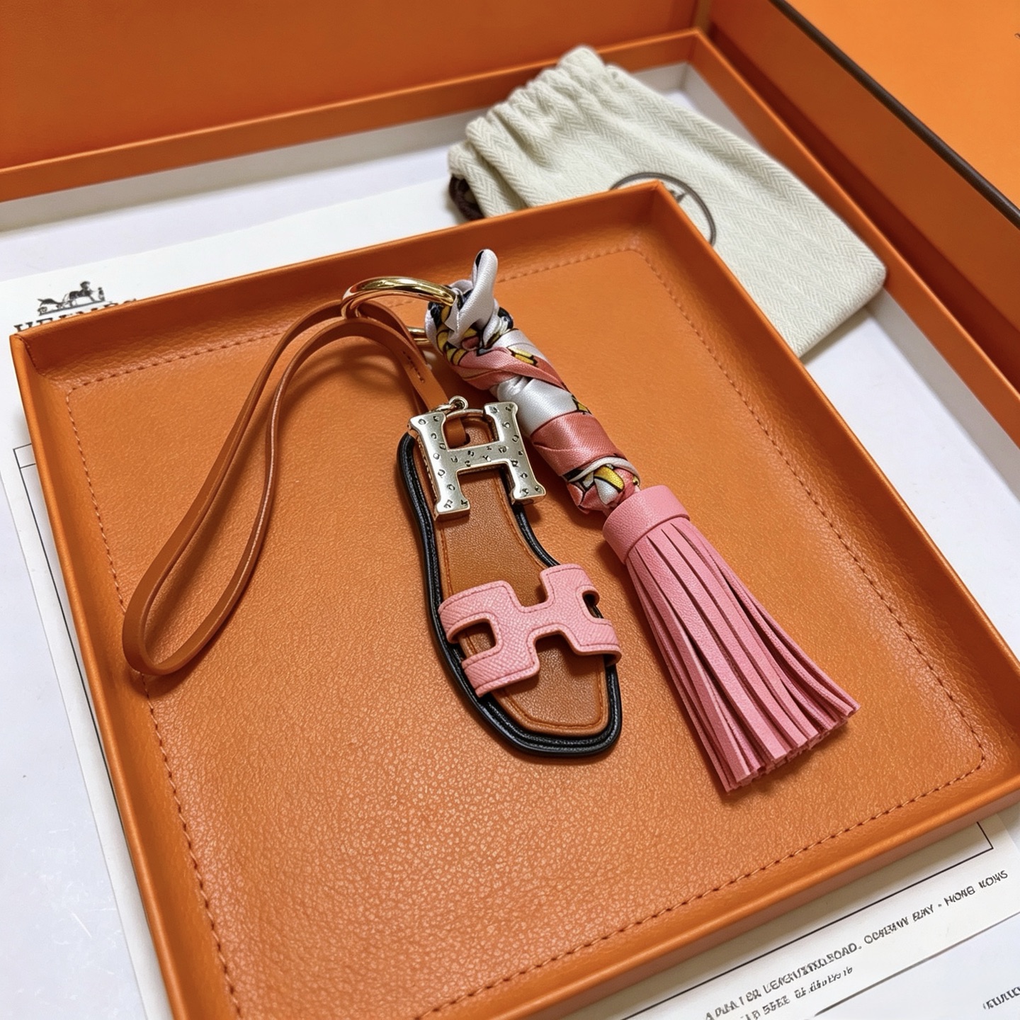 Hermes Oran Sandalo Nappa Chiave Ciondolo ciondolo Metallo tonalità oro Hardware H tonalità argento pelle marrone chiaro pelle rosa seta stampata multicolore bordo nero finiture 12 cm lunghezza totale