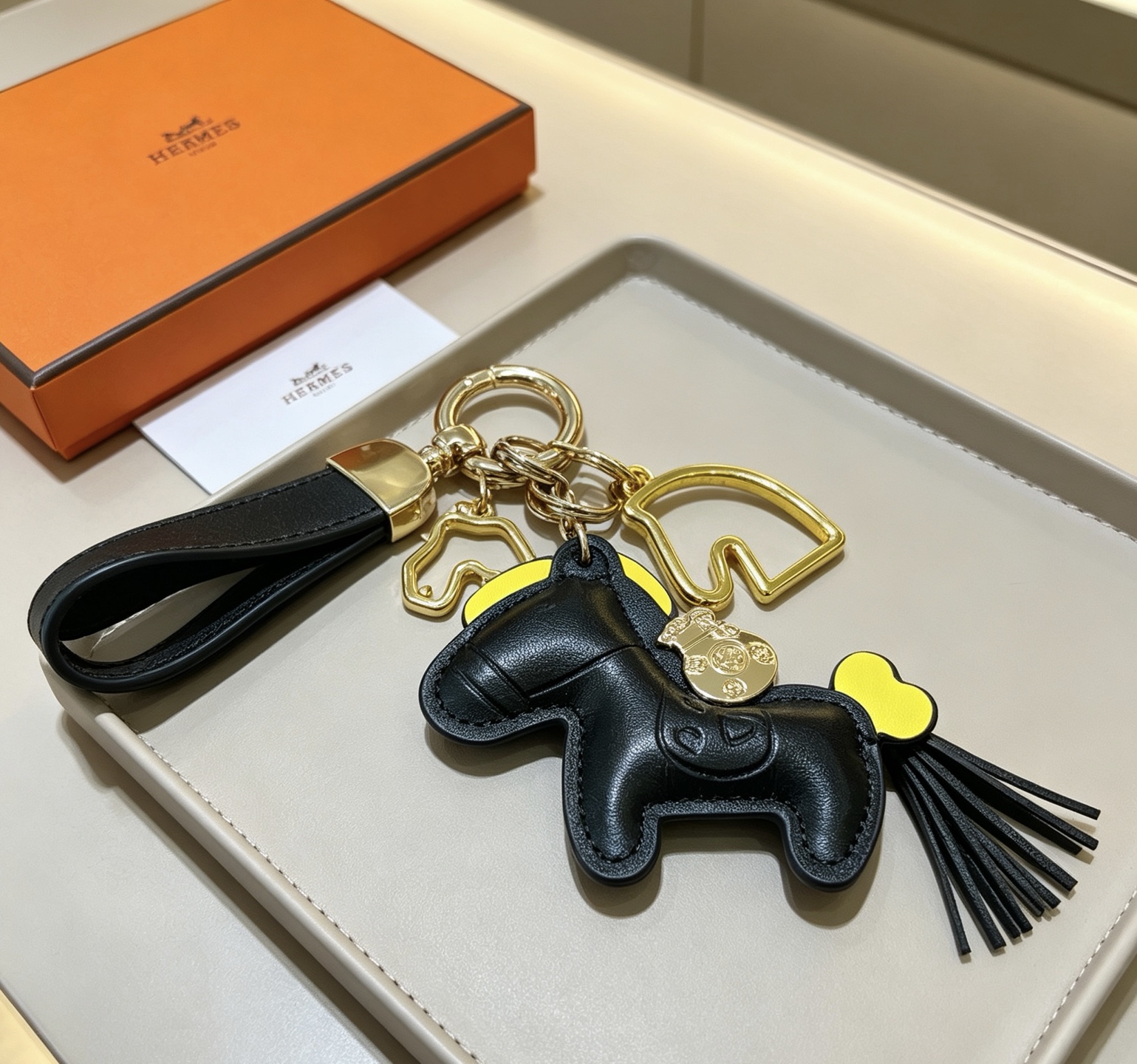 Hermes Rodeo Horse Money Bag Charm Portachiavi Ciondolo Pelle nera con accenti gialli Hardware in metallo color oro Lunghezza totale 12 cm