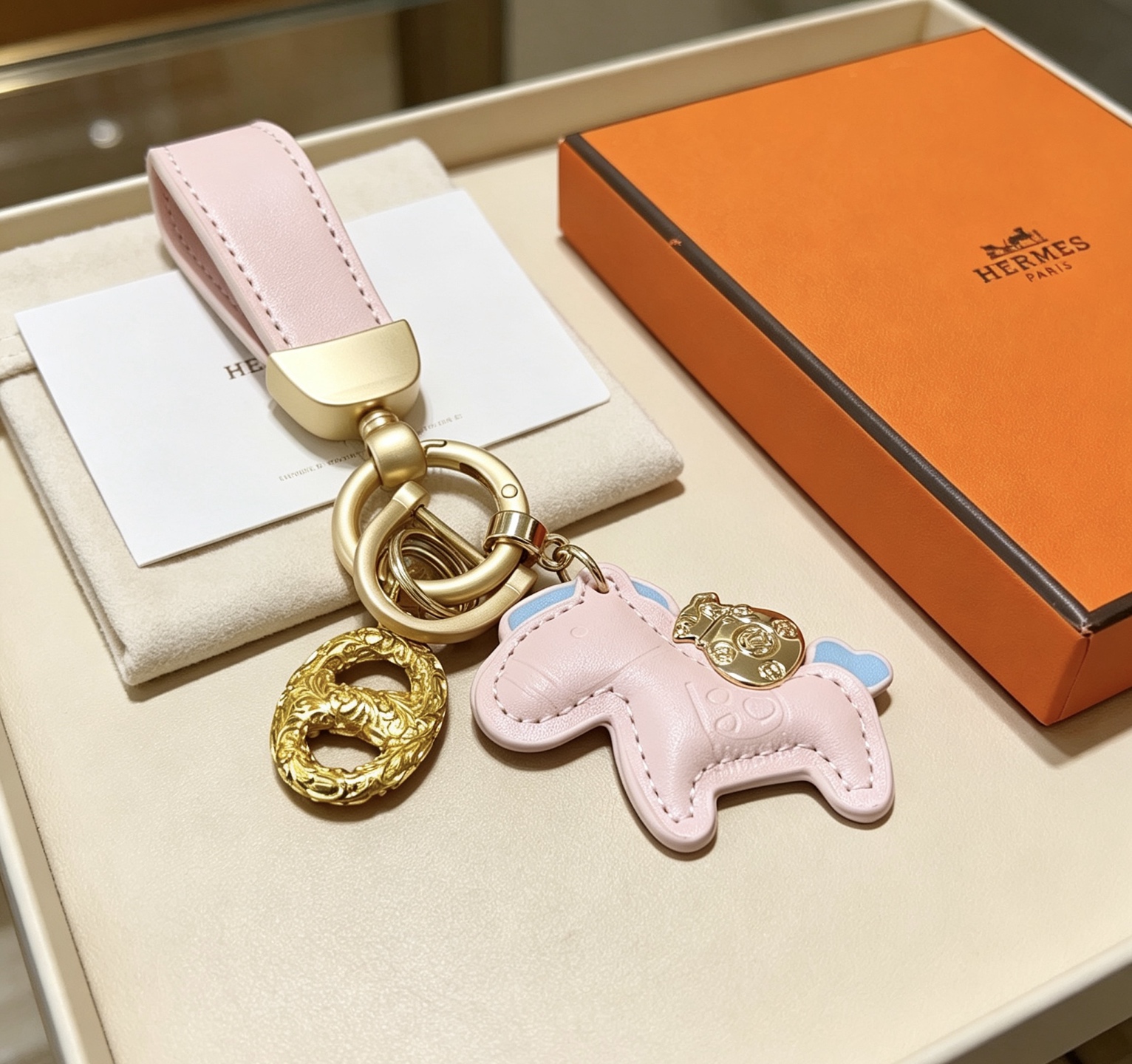 Ciondolo Hermes Rodeo Pony Key Pelle rosa chiaro con accenti azzurri Hardware in metallo color oro Lunghezza totale 12 cm