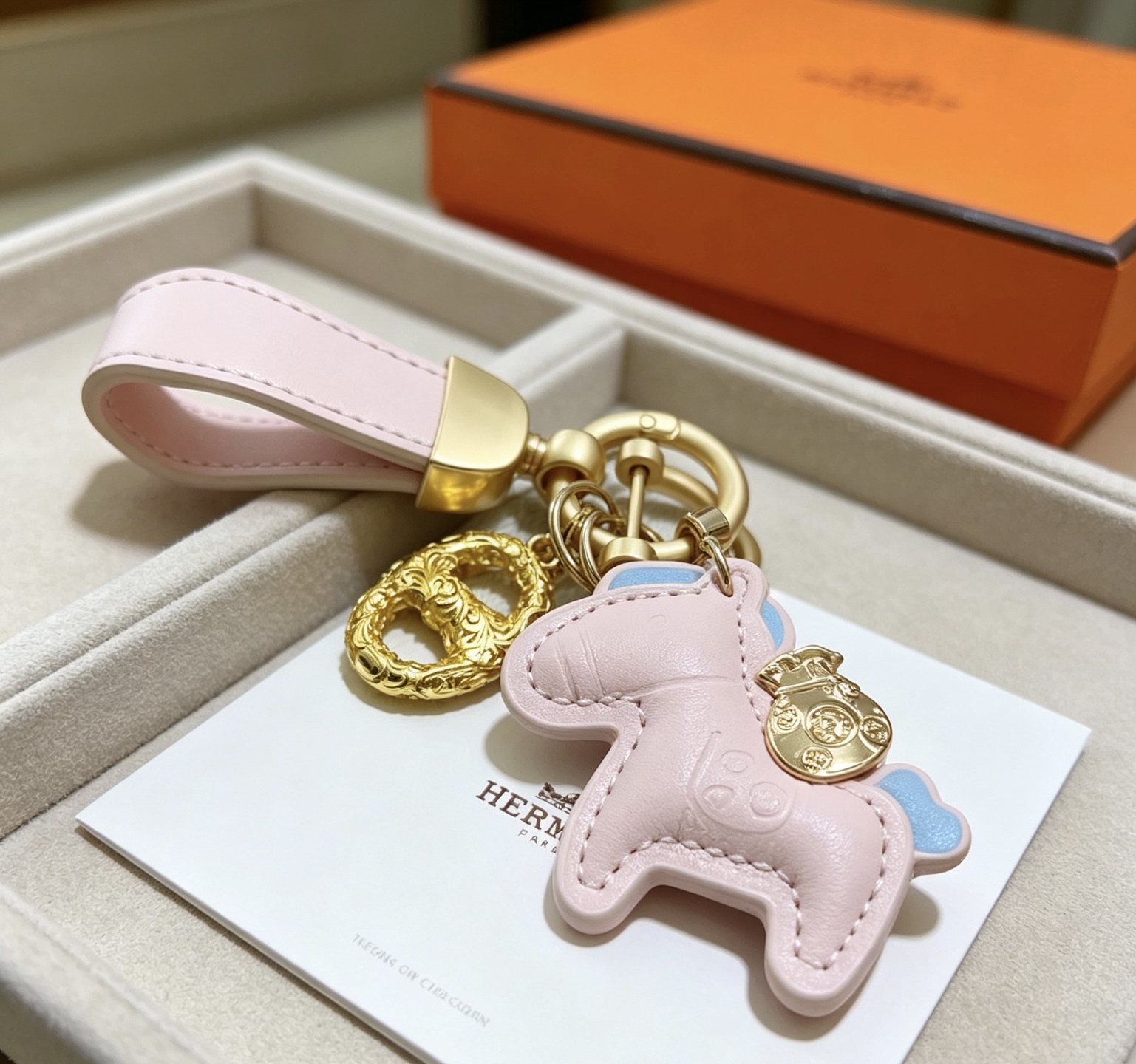 Ciondolo Hermes Rodeo Pony Key Pelle rosa chiaro con accenti azzurri Hardware in metallo color oro Lunghezza totale 12 cm