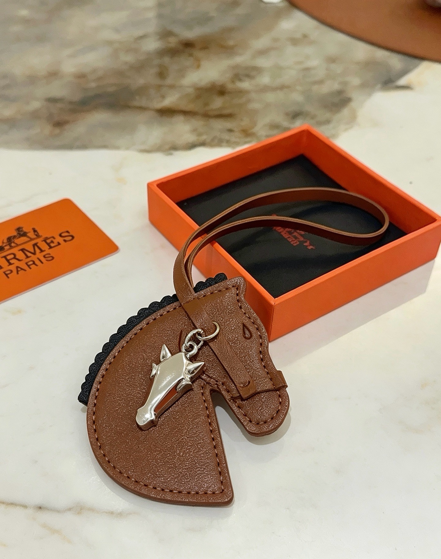 Hermes Geegee Horse Head Bag Charm colgante de cuero marrón con adornos negros, herrajes de metal en tono plateado, longitud de la correa de 12 cm