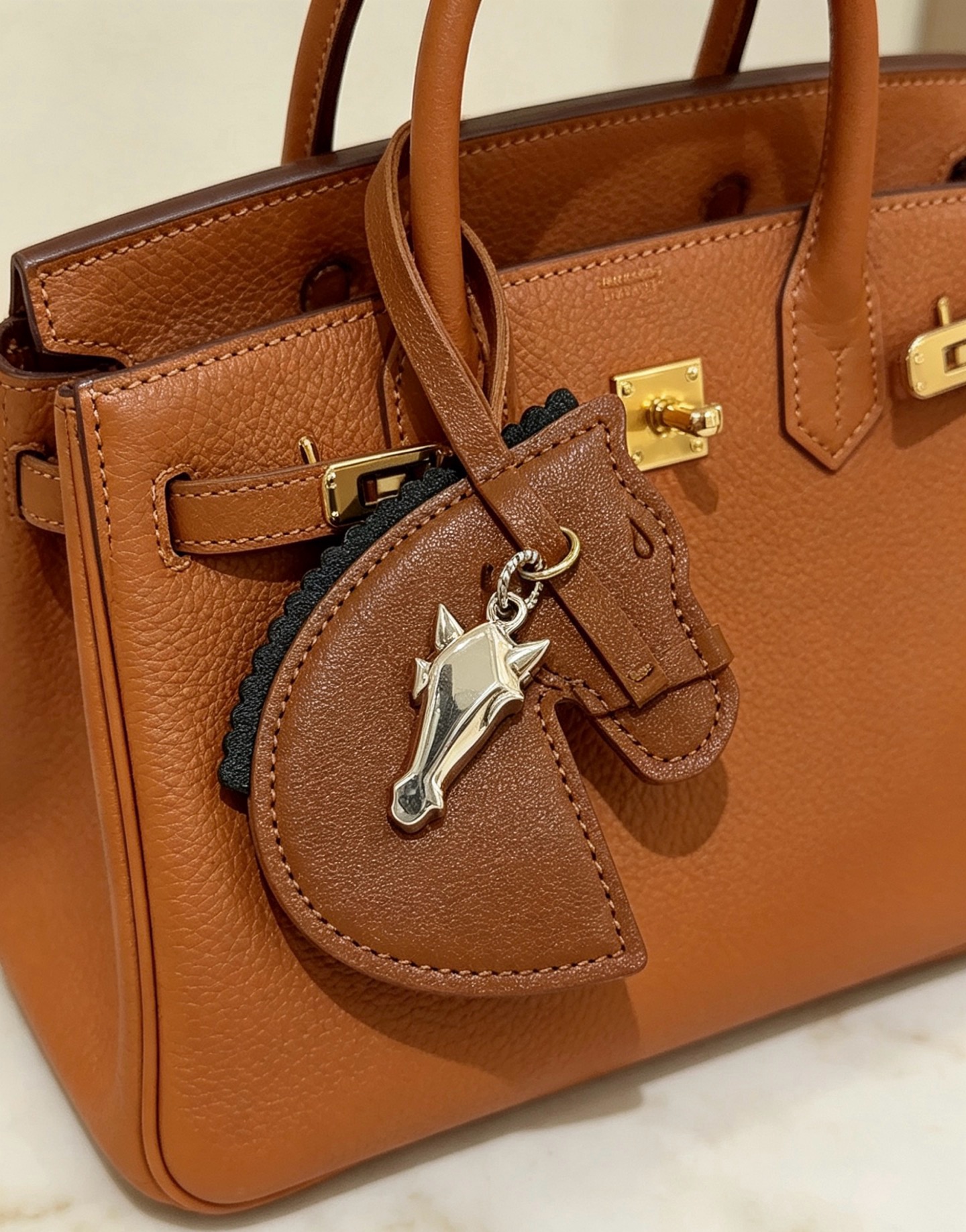 Hermes Geegee Horse Head Bag Charm colgante de cuero marrón con adornos negros, herrajes de metal en tono plateado, longitud de la correa de 12 cm