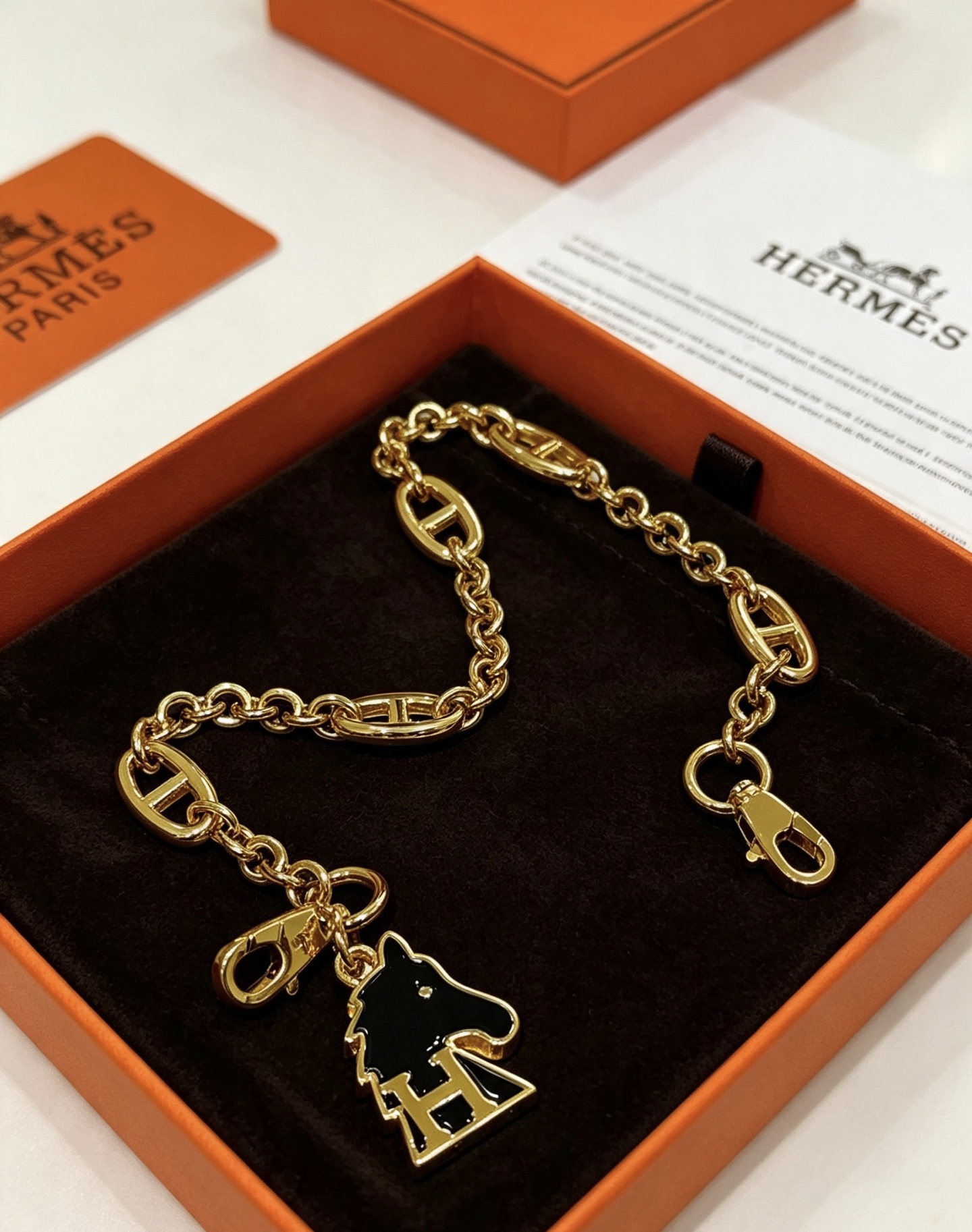 Hermes Cheval H Bag Charm Ciondolo a catena in metallo color oro con smalto nero, lunghezza della catena di 16 cm
