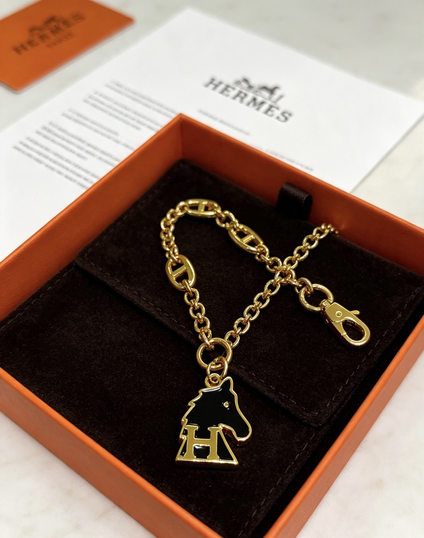 Hermes Cheval H Bag Charm Ciondolo a catena in metallo color oro con smalto nero, lunghezza della catena di 16 cm