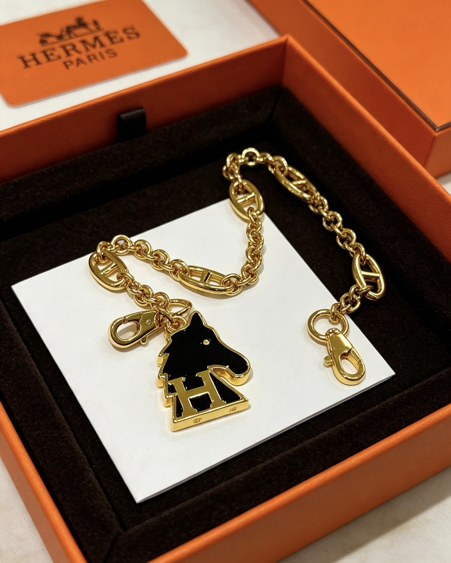 Hermes Cheval H Bag Charm Ciondolo a catena in metallo color oro con smalto nero, lunghezza della catena di 16 cm