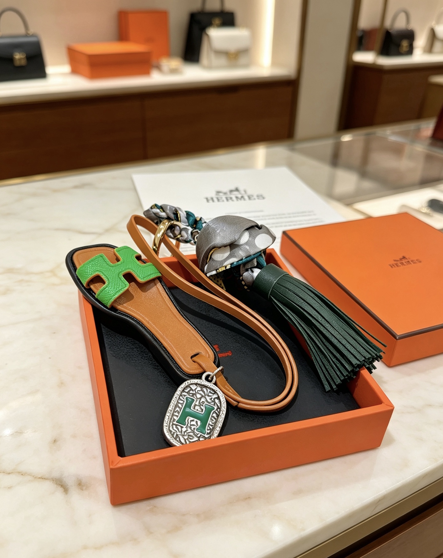 Hermes Oran Sandalo Borsa con nappa Ciondolo con ciondolo Metallo color oro pelle marrone chiaro pelle verde brillante pelle verde scuro seta a pois grigi metallo argentato con smalto verde Dettaglio H 12 cm lunghezza totale