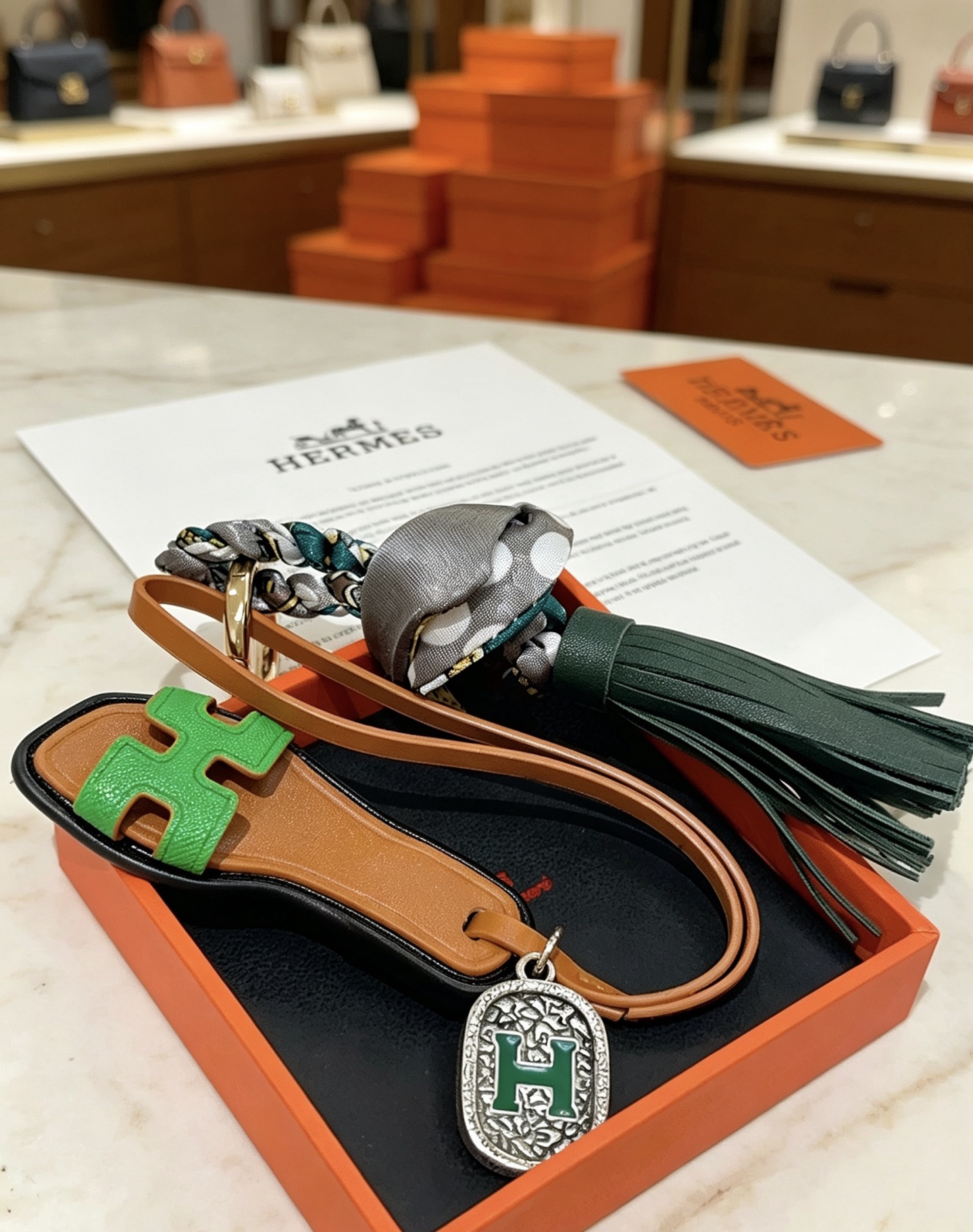 Hermes Oran Sandalo Borsa con nappa Ciondolo con ciondolo Metallo color oro pelle marrone chiaro pelle verde brillante pelle verde scuro seta a pois grigi metallo argentato con smalto verde Dettaglio H 12 cm lunghezza totale