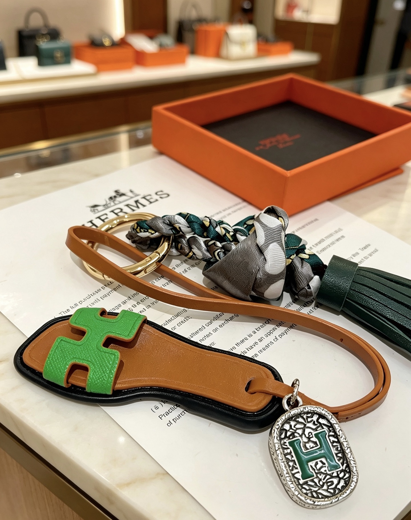 Hermes Oran Sandalo Borsa con nappa Ciondolo con ciondolo Metallo color oro pelle marrone chiaro pelle verde brillante pelle verde scuro seta a pois grigi metallo argentato con smalto verde Dettaglio H 12 cm lunghezza totale